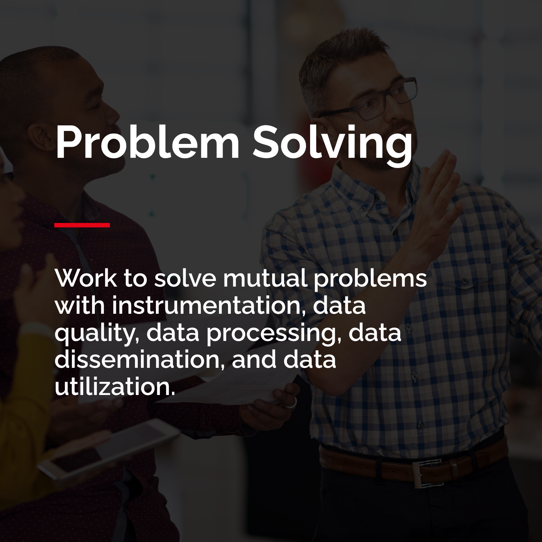 a guy showing other people something on a written board showing how COSMOS works to solve problems with data quality, processing, dissemination and utilization.