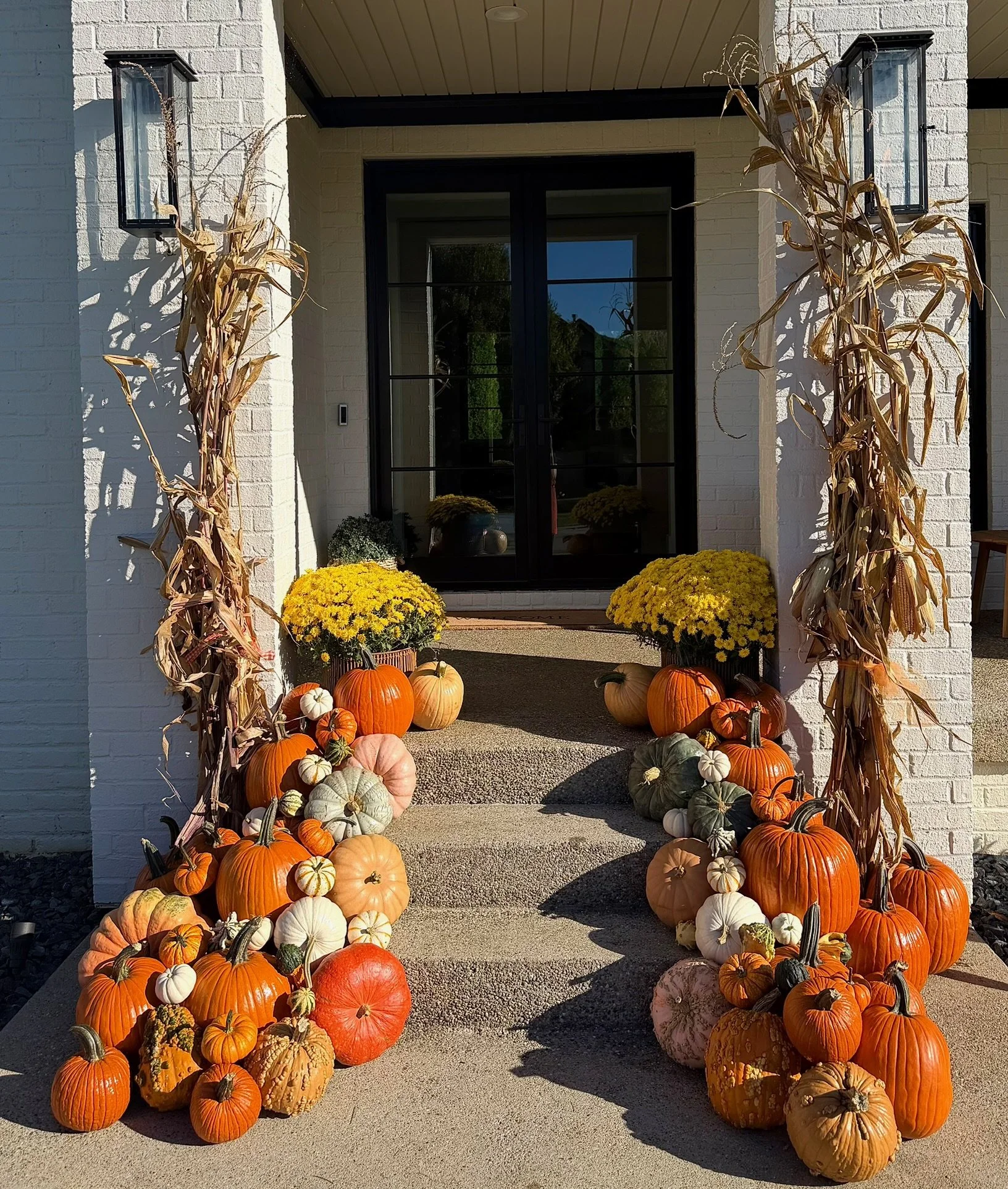 Oldham County fall porch display featuring premium pumpkins, cornstalks, mums, and seasonal styling.