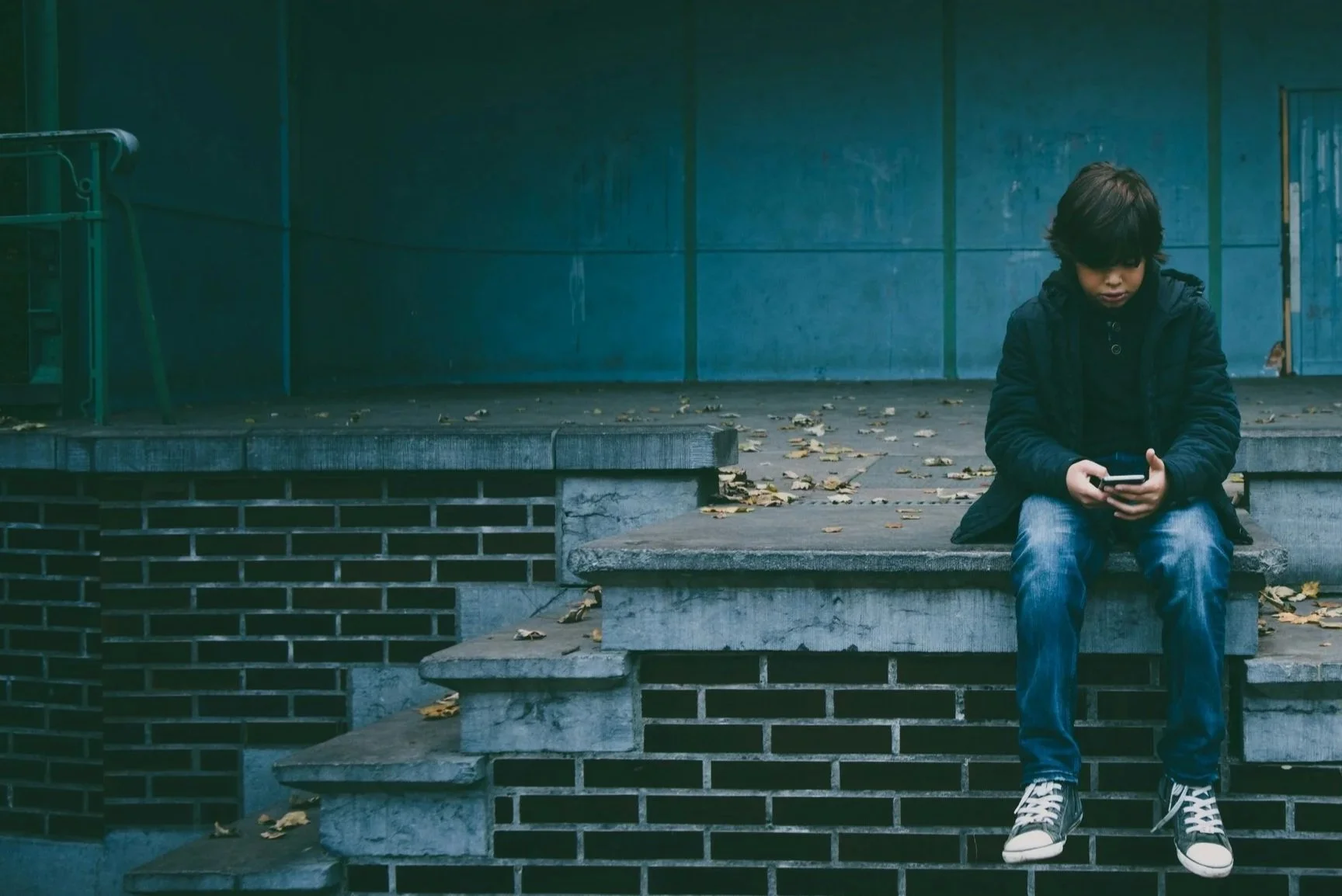 Kind mit Smartphone als Symbol für digitalen Kinderschutz von UNAL IT Solutions.