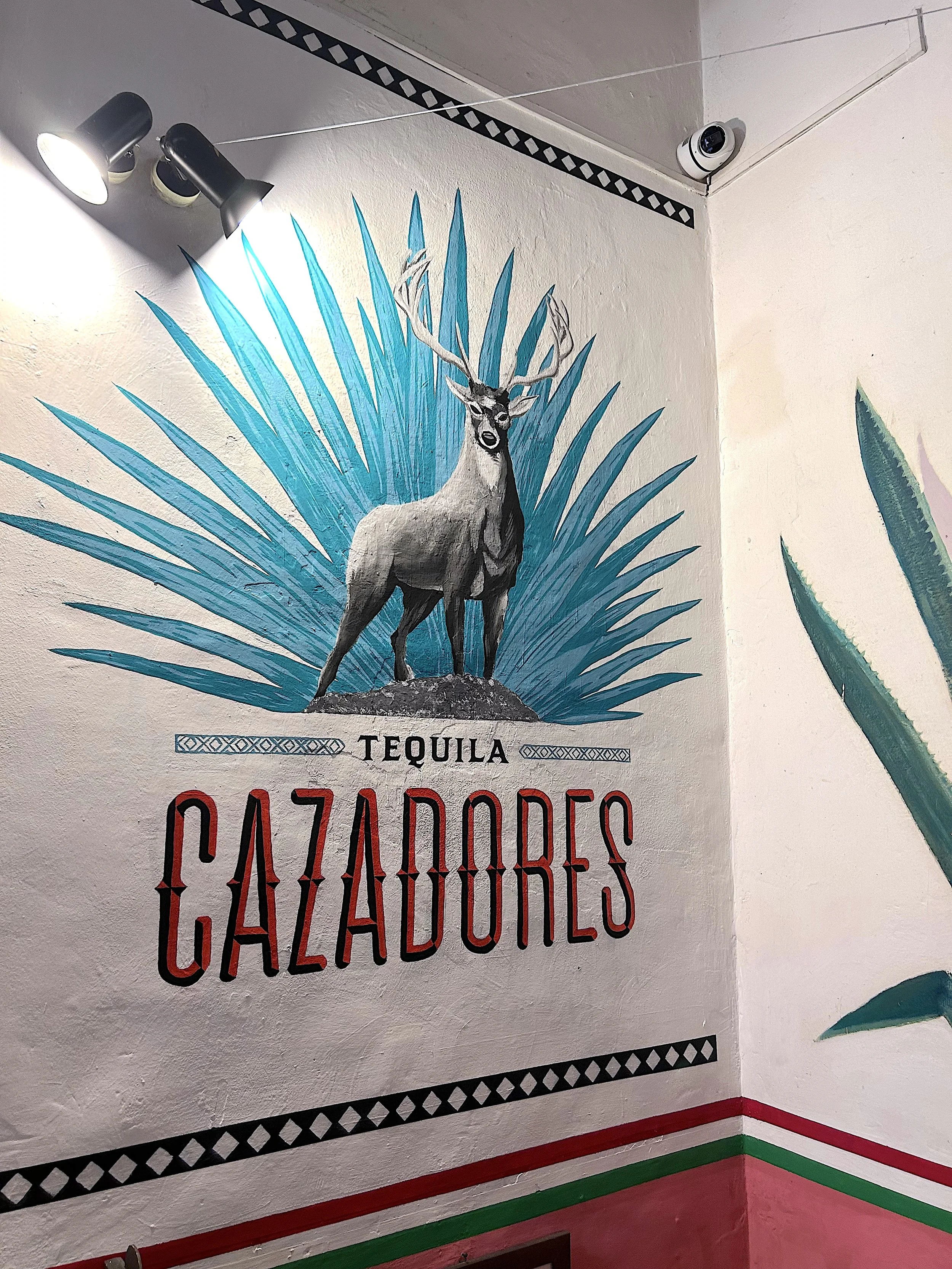 Murale decorativa con una fiere di un cervo e foglie di agave, con la scritta 'Tequila GAZODORES'.