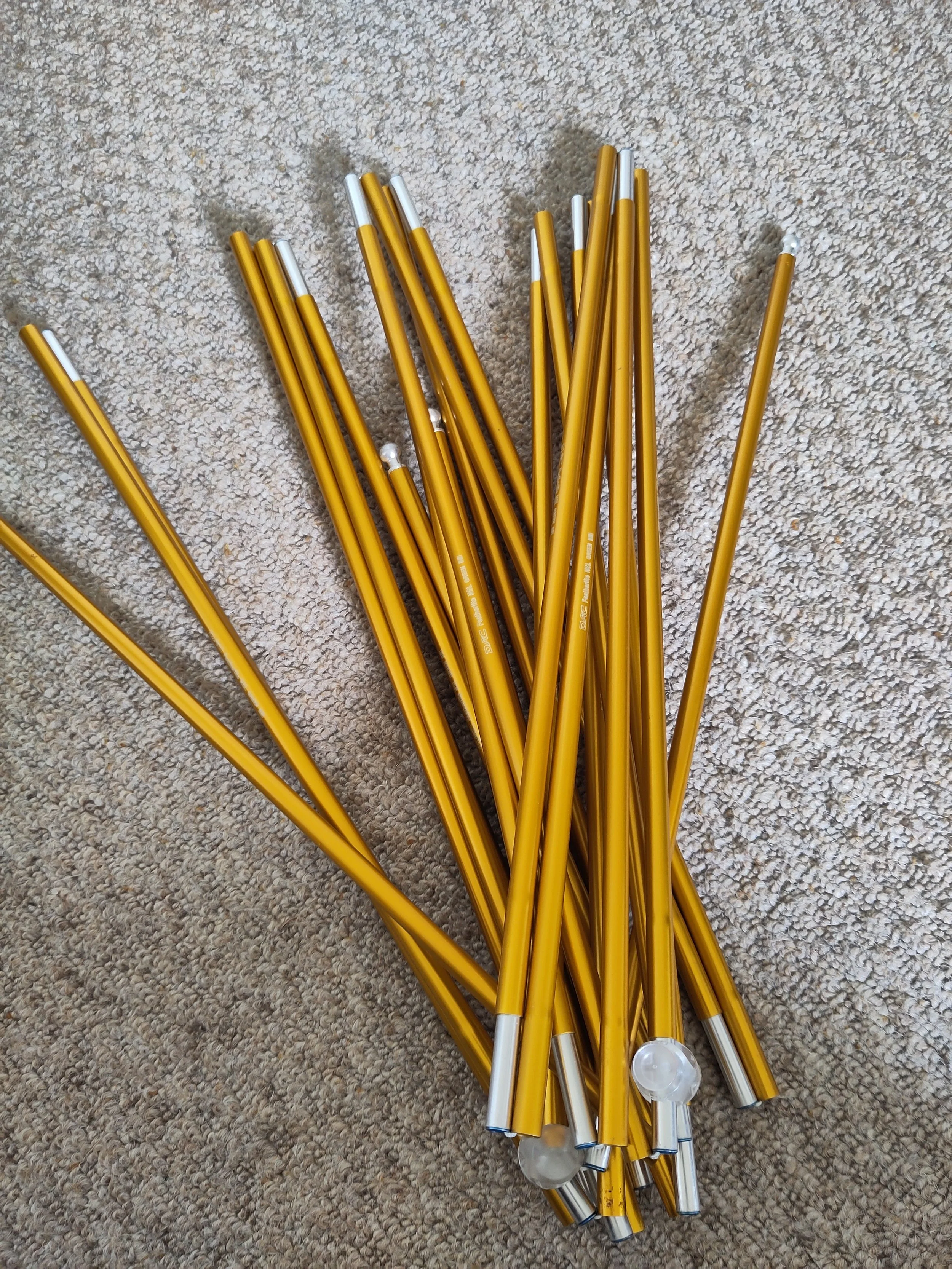 A pile of yellow and white LED string lights with silver tips on a beige carpet.