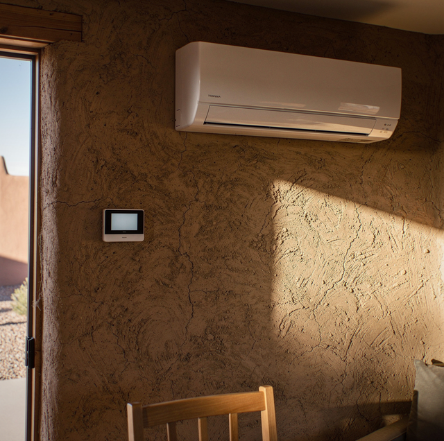 white ductless mini-split mounted on adobe wall above doorway