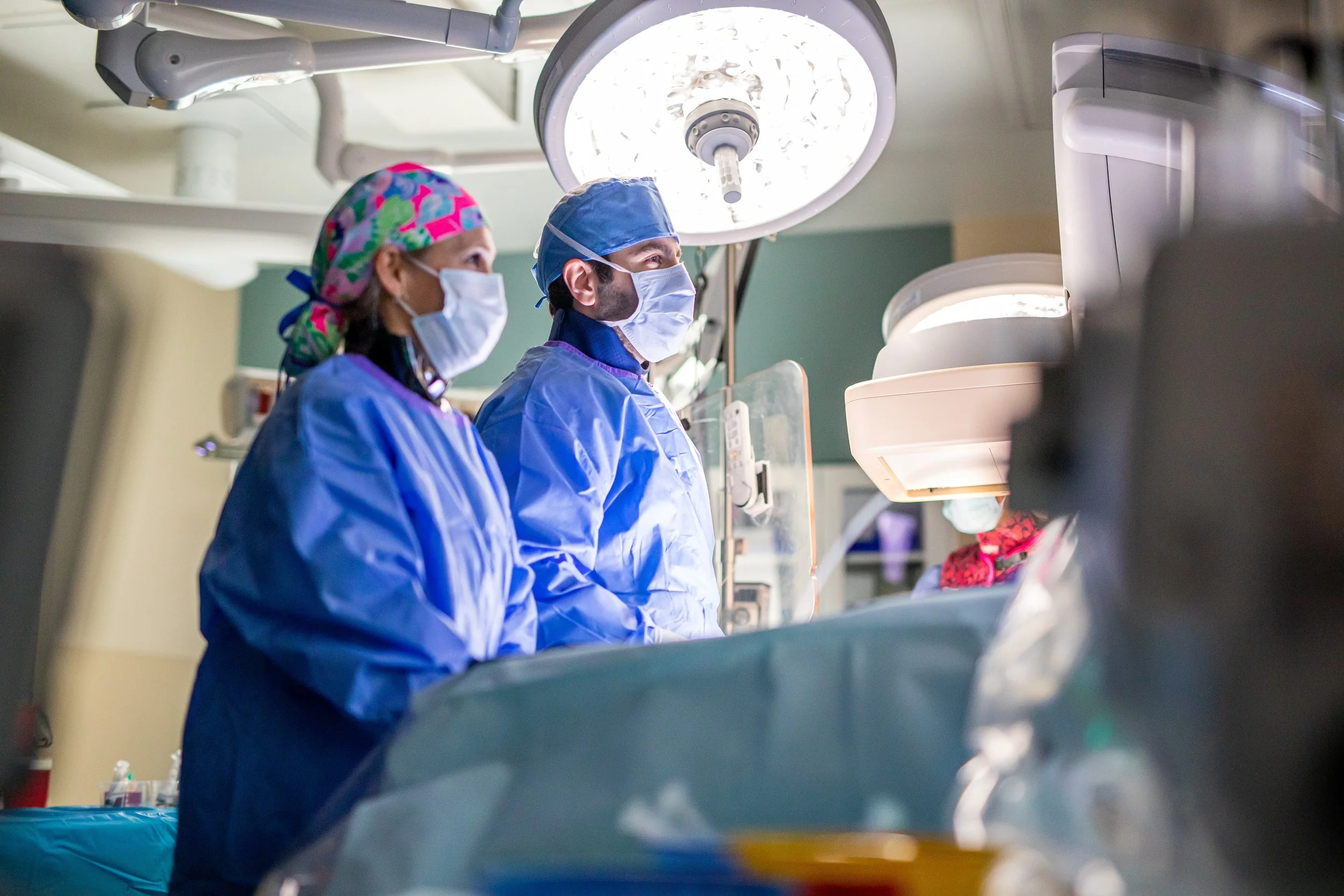 Surgical team members work together in an operating room, reflecting focused expertise, collaboration, and compassionate care.