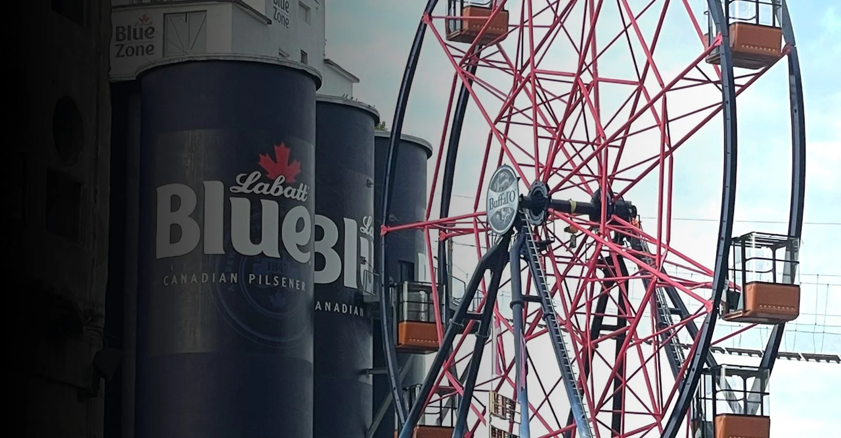 Red and black Ferris wheel with orange cabins, next to a building with B.C. Brewery cans and a sign that reads "Blue Zone".