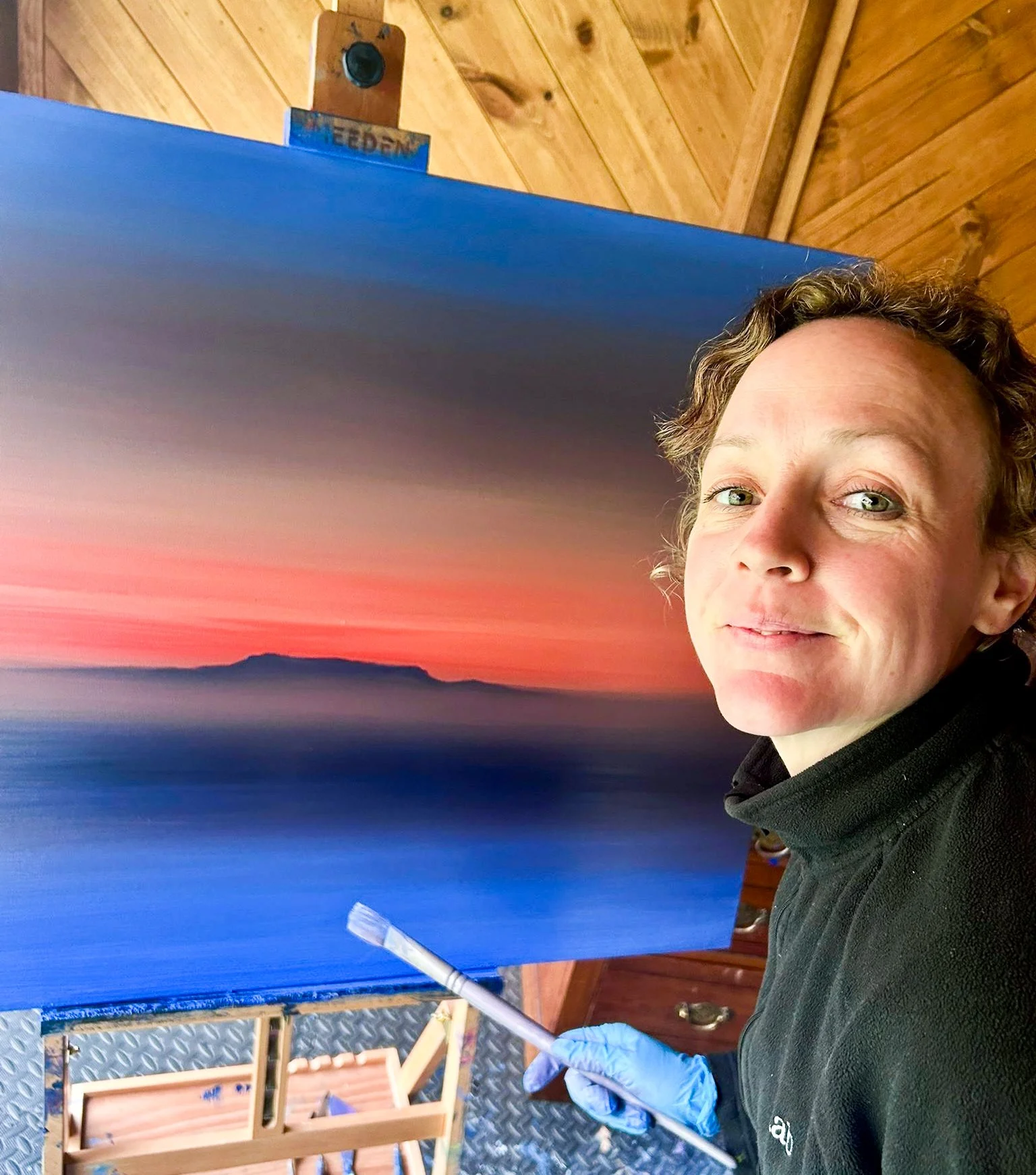 Impressionist artist, Cat Goward painting Table Mountain in her studio - a commissioned piece of artwork in vibrant colours.