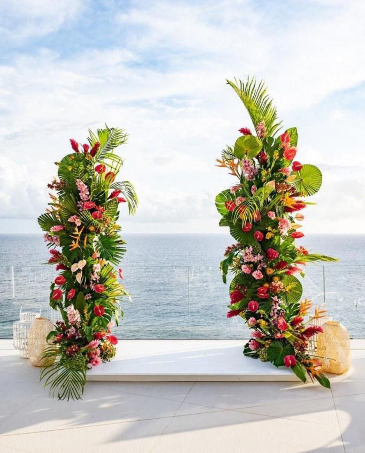 Luxury tropical floral arch with white and coral flowers for a seaside wedding in St Barth.