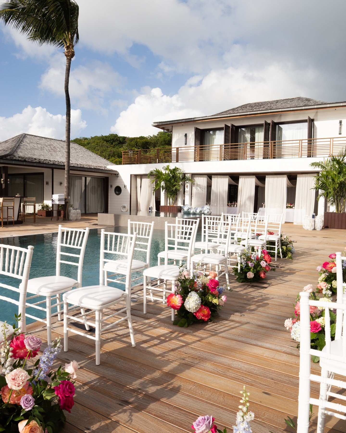 A ceremony framed by palms, pool reflections, and bursts of vibrant florals.
Disco balls catching the St-Barth sun, aisle arrangements popping with colour...
Nicola &amp; Jo&rsquo;s &ldquo;I do&rdquo; at Villa Blanc Bleu set the tone: bold, joyful, a