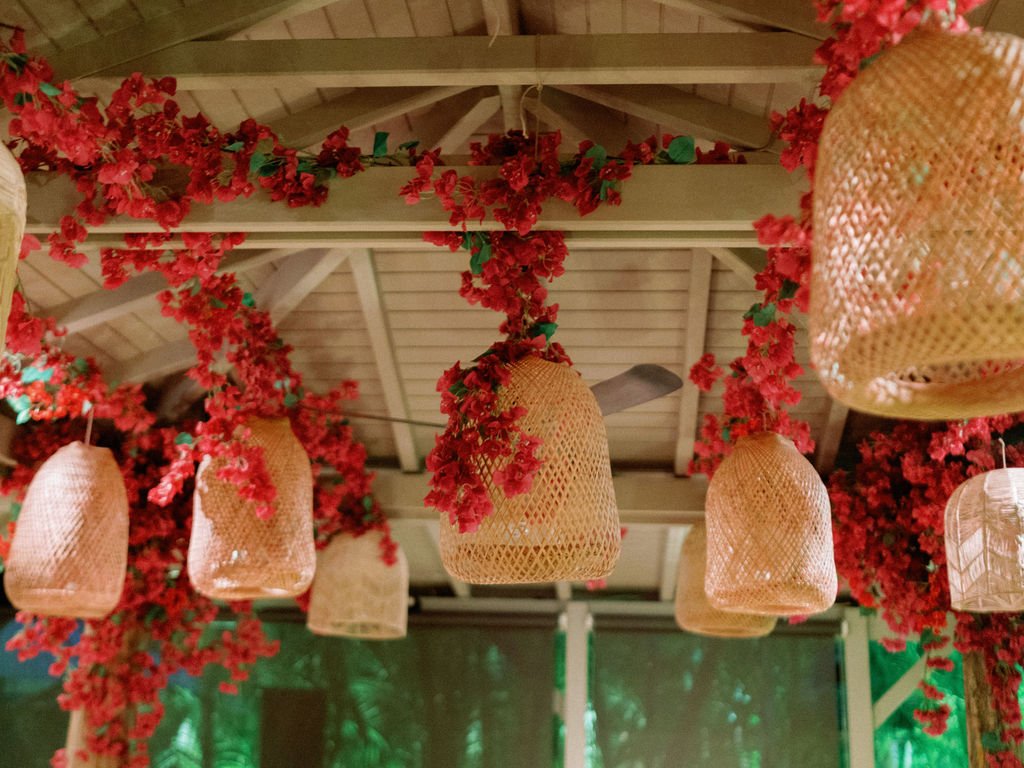 Ceiling decor with hanging fuchsia bougainvillea and rattan lamps for a bohemian wedding in St Barth.