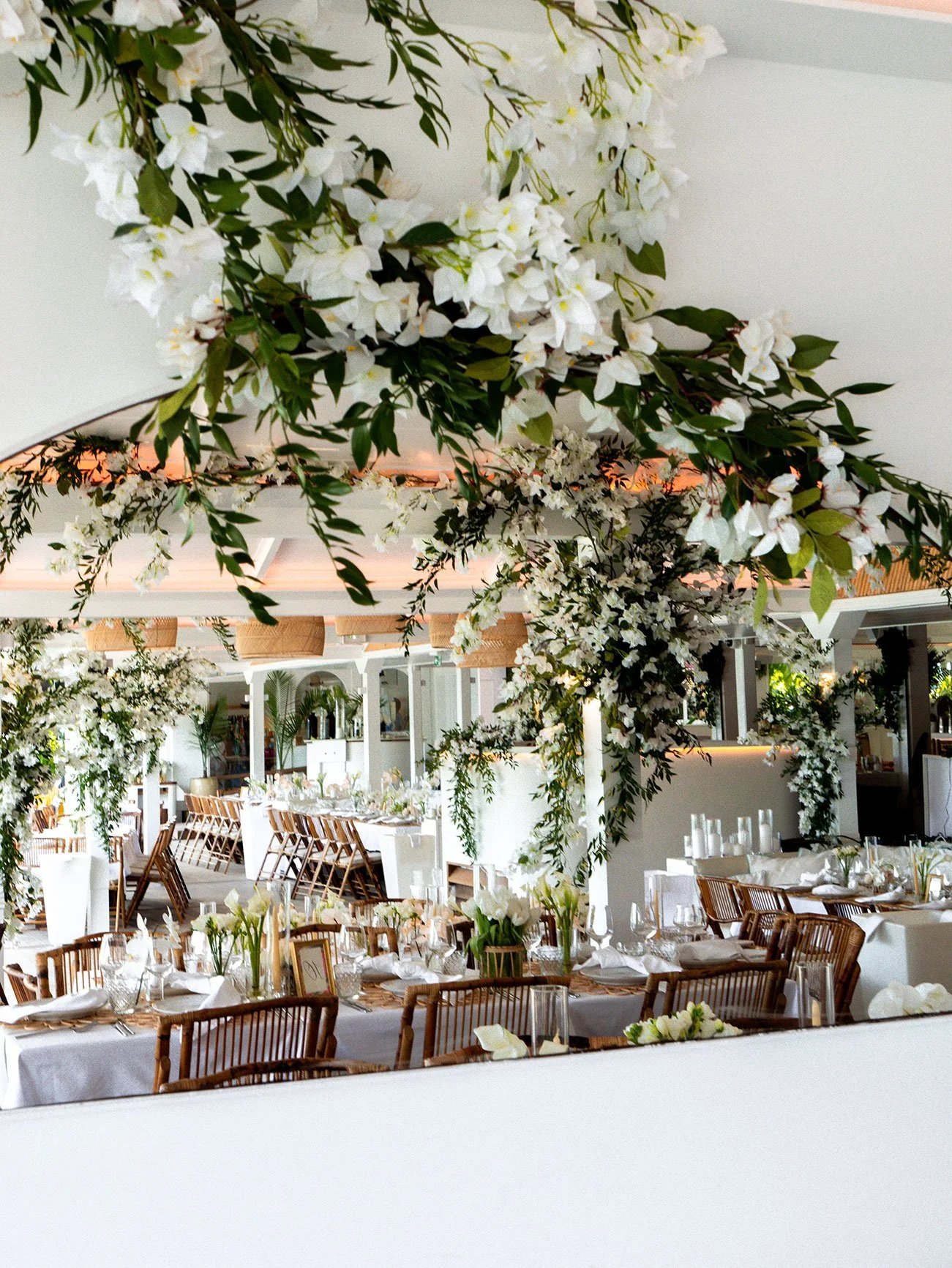 Tropical wedding reception filled with greenery, natural textures, and warm lighting in St Barth.