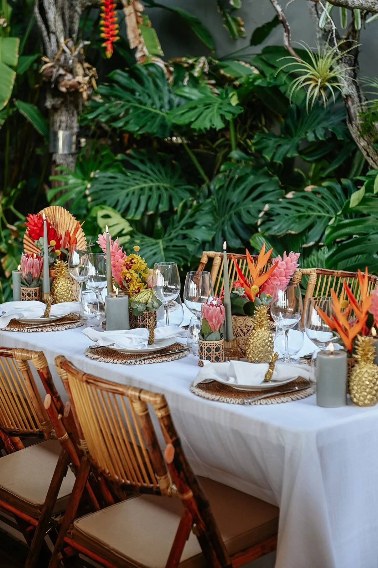 Outdoor wedding table decorated with orange tropical flowers and greenery for a vibrant event in St Barth.
