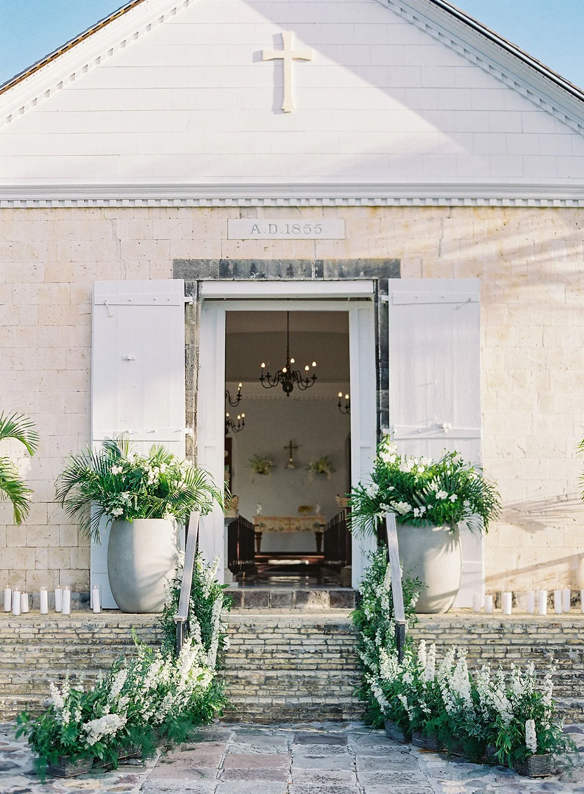 Elegant floral doorway with lush arrangements welcoming guests to a refined wedding venue in St Barth.