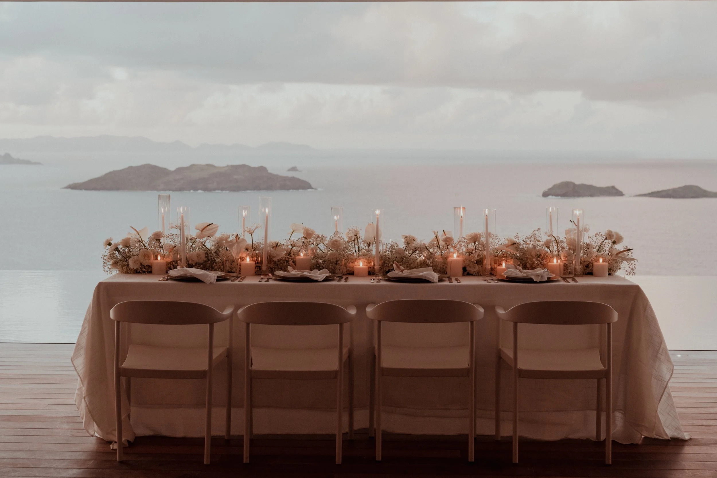 Luxury beachside wedding table setup illuminated by warm lighting for an evening celebration in St Barth.