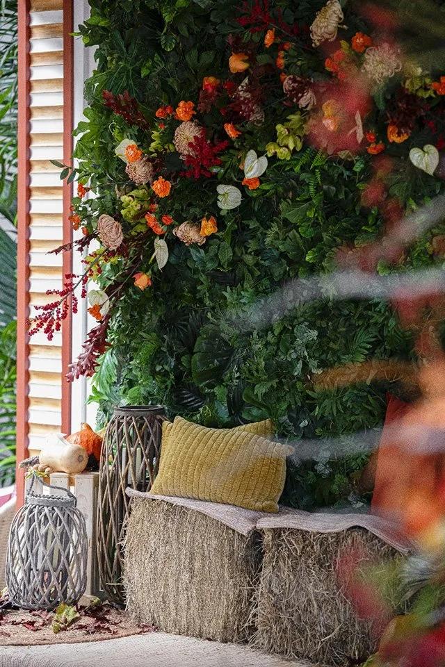 Tropical lounge corner with colorful floral wall decor and natural textures for a luxury wedding event in St Barth.