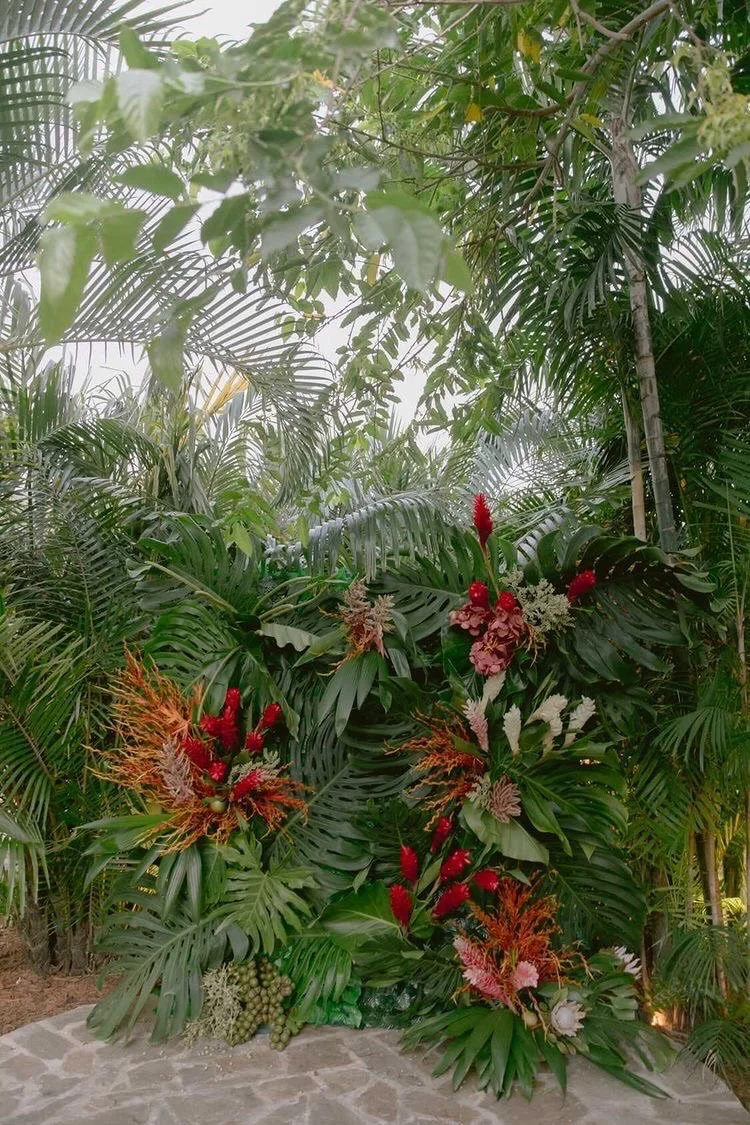 Lush tropical greenery wall with exotic flowers for a natural and elegant wedding atmosphere in St Barth.