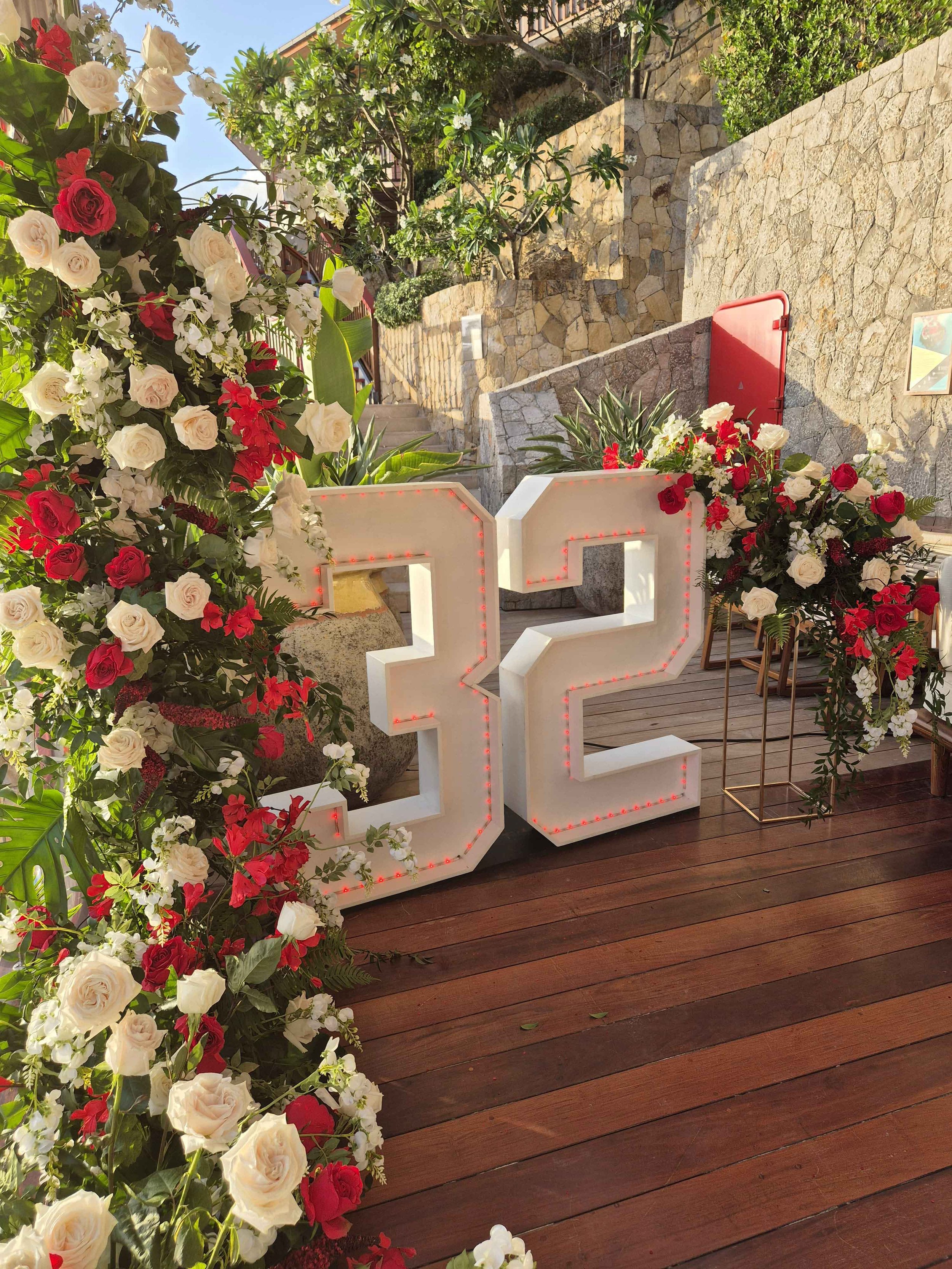 Event floral installation featuring the number 32 surrounded by red and white flowers for a celebration in St Barth.