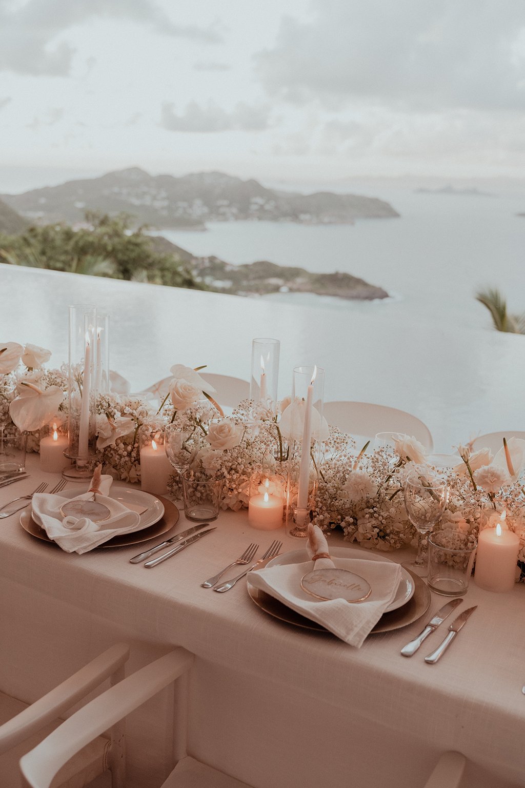 Elegant wedding table decorated with white flowers and candles overlooking the sea in St Barth.