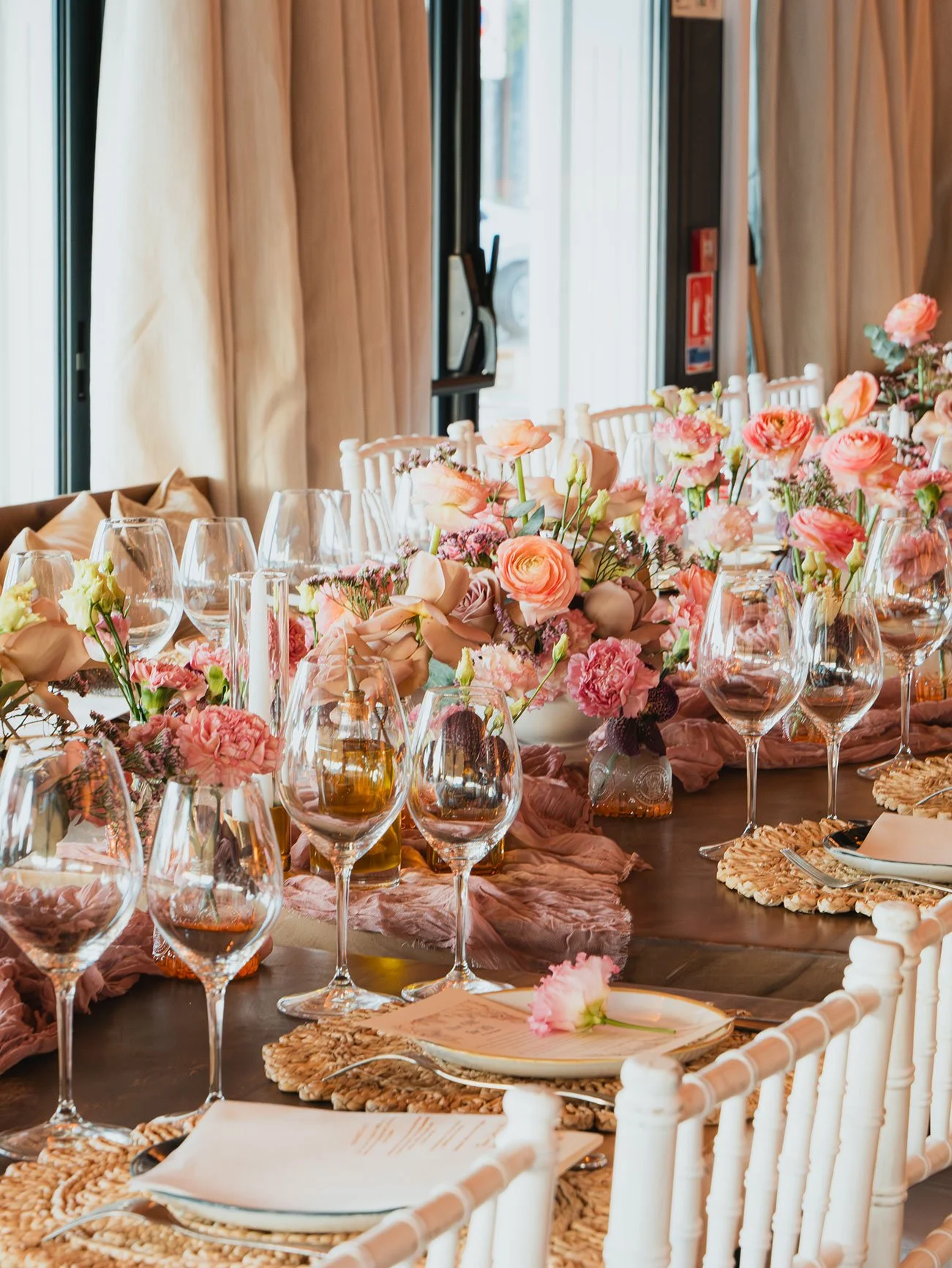 Festive event table decorated with pink flowers, sparkling details, wine glasses, and elegant tableware for a chic celebration in St Barth.