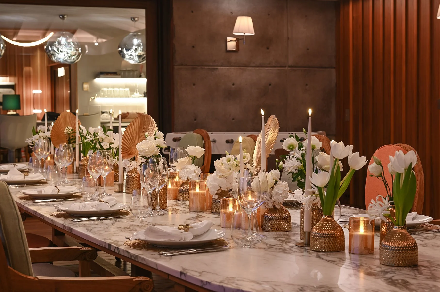 Chic wedding table decorated with white and gold floral arrangements and candlelight in St Barth.