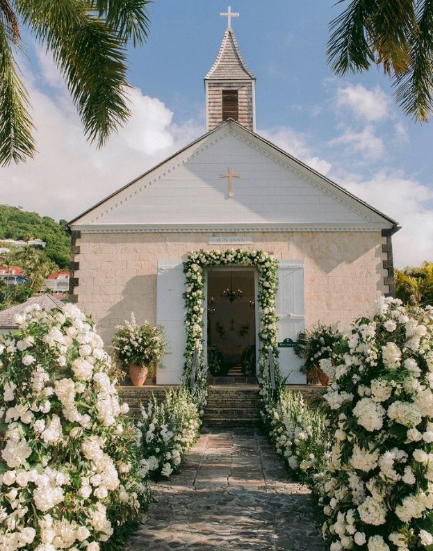 Iconic white chapel adorned with lush floral arrangements for a wedding in St Barth.