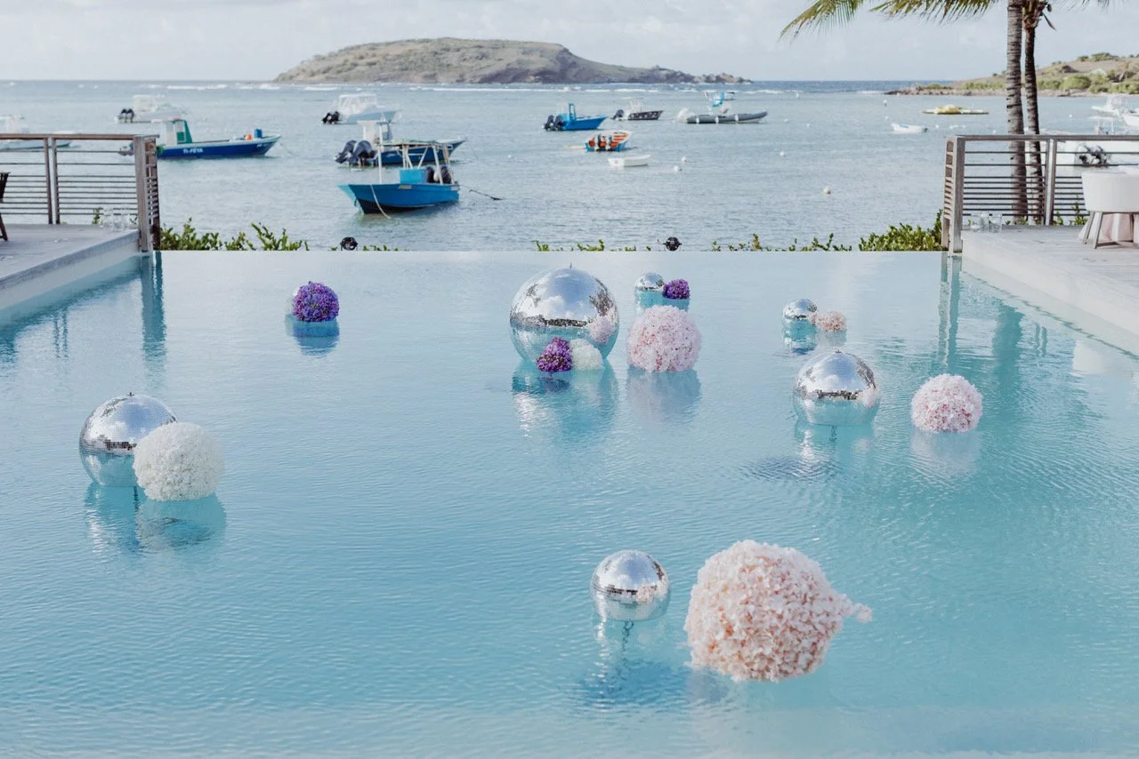 Floating floral arrangements on turquoise water for a luxury tropical wedding event in St Barth.