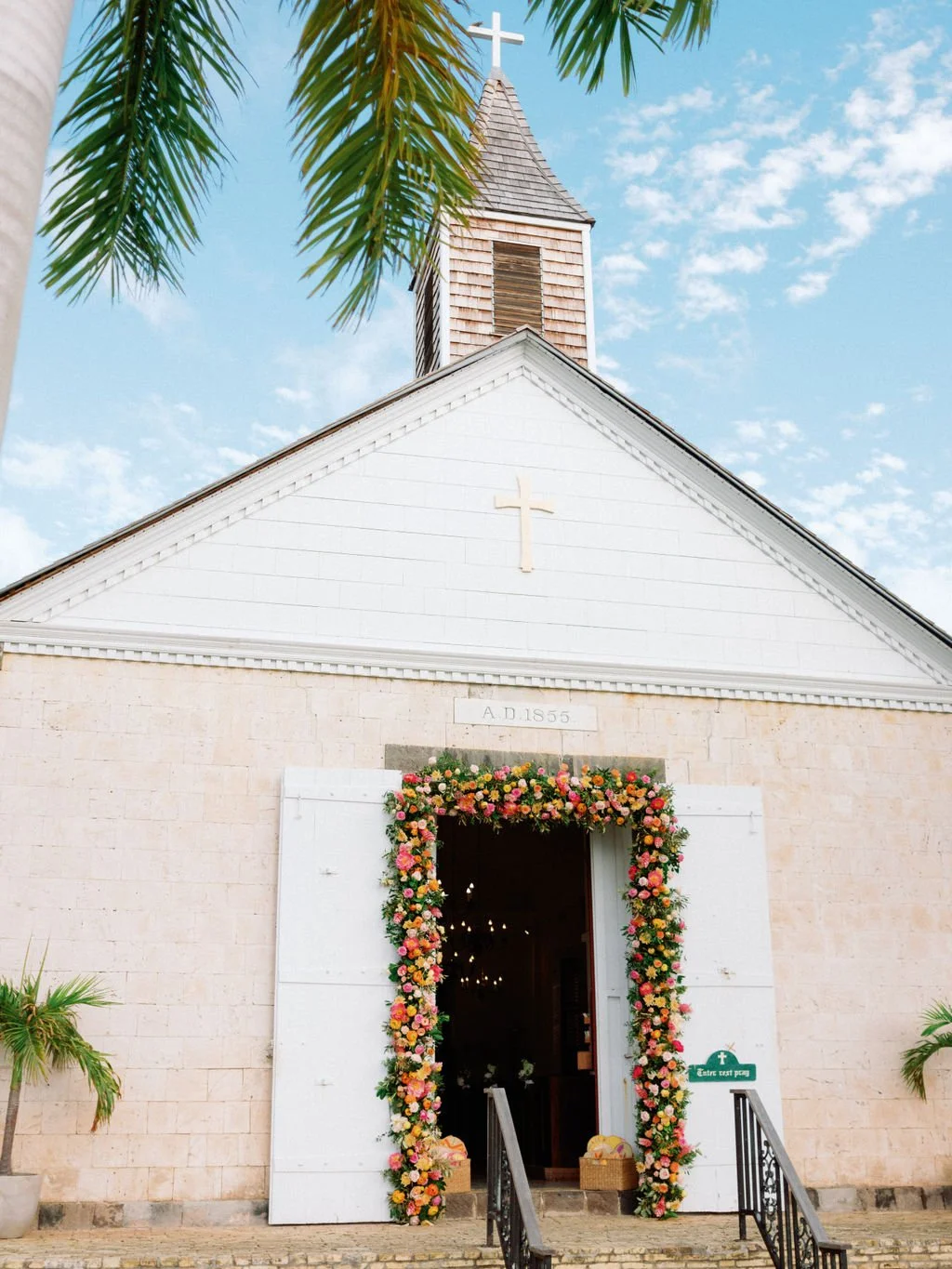 Lush tropical wedding arch surrounded by palm trees and greenery in St Barth.