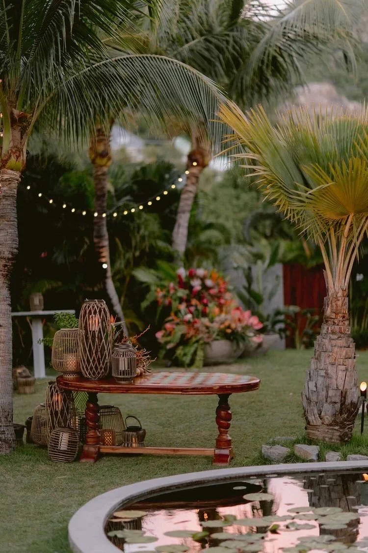 Bohemian outdoor event table with wooden decor, lanterns, and tropical plants creating a cozy and elegant ambiance in St Barth.