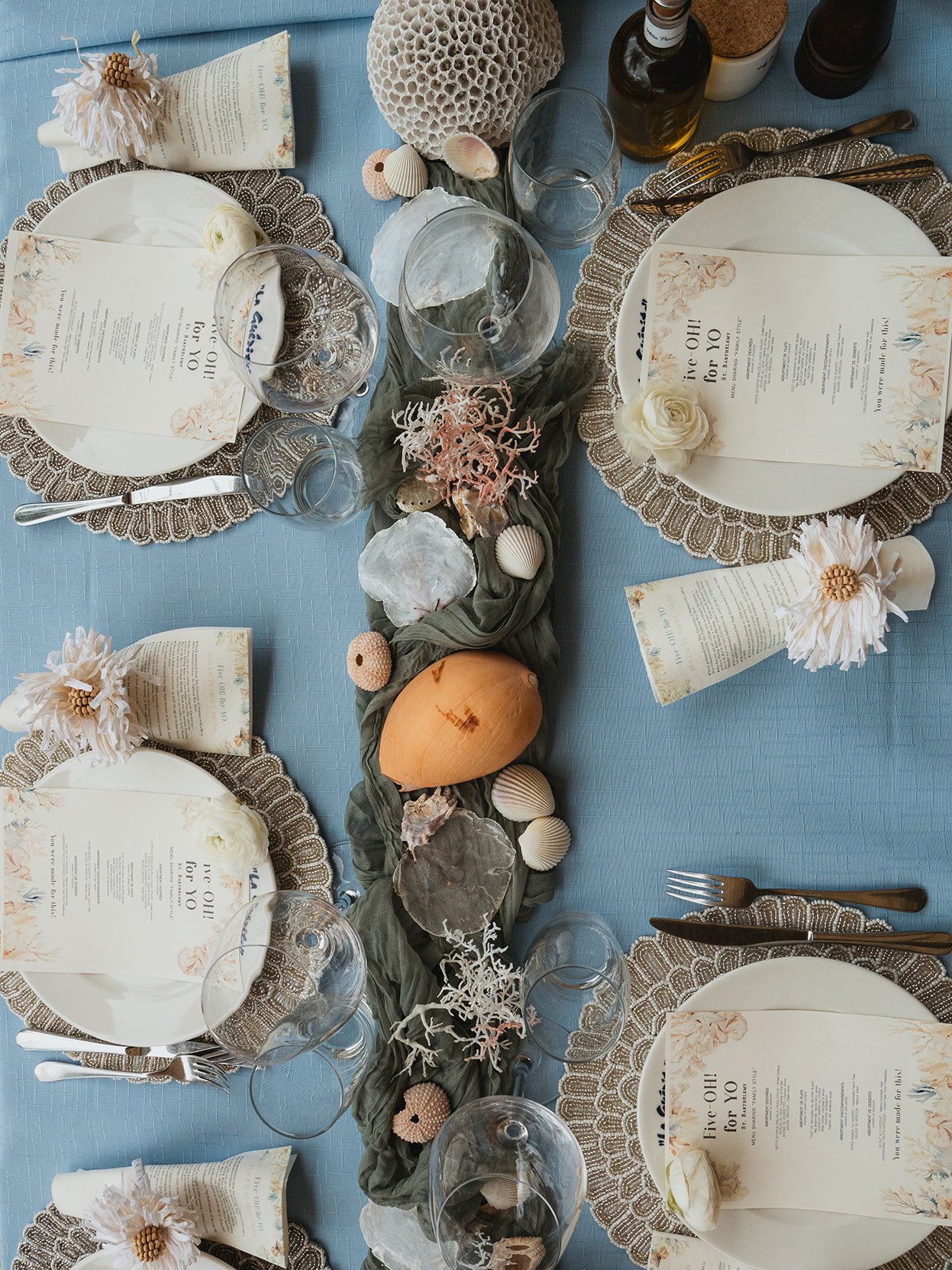 Coastal wedding table decorated with shells, natural textures, and elegant plates in St Barth.