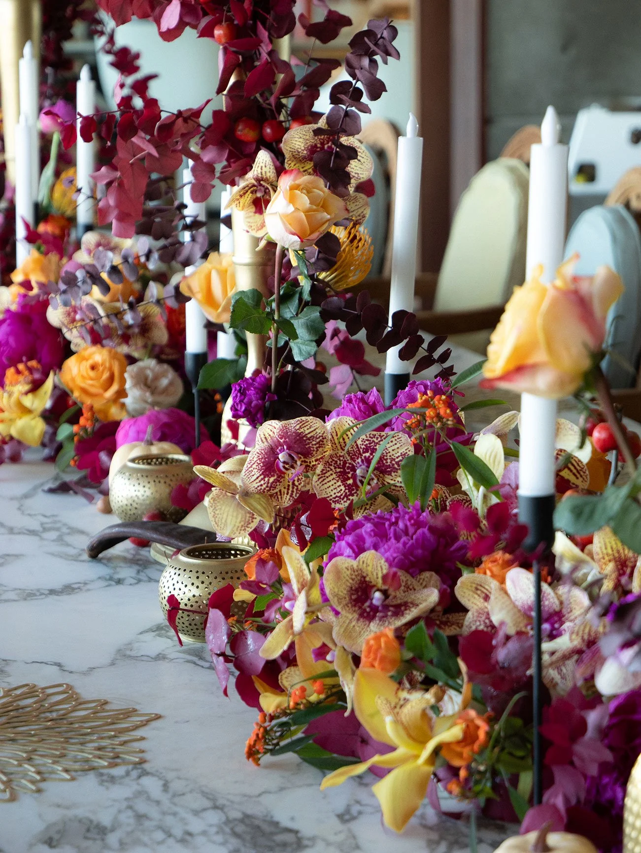 Vibrant wedding table with colorful floral arrangements, candles, and elegant tableware for a festive event in St Barth.