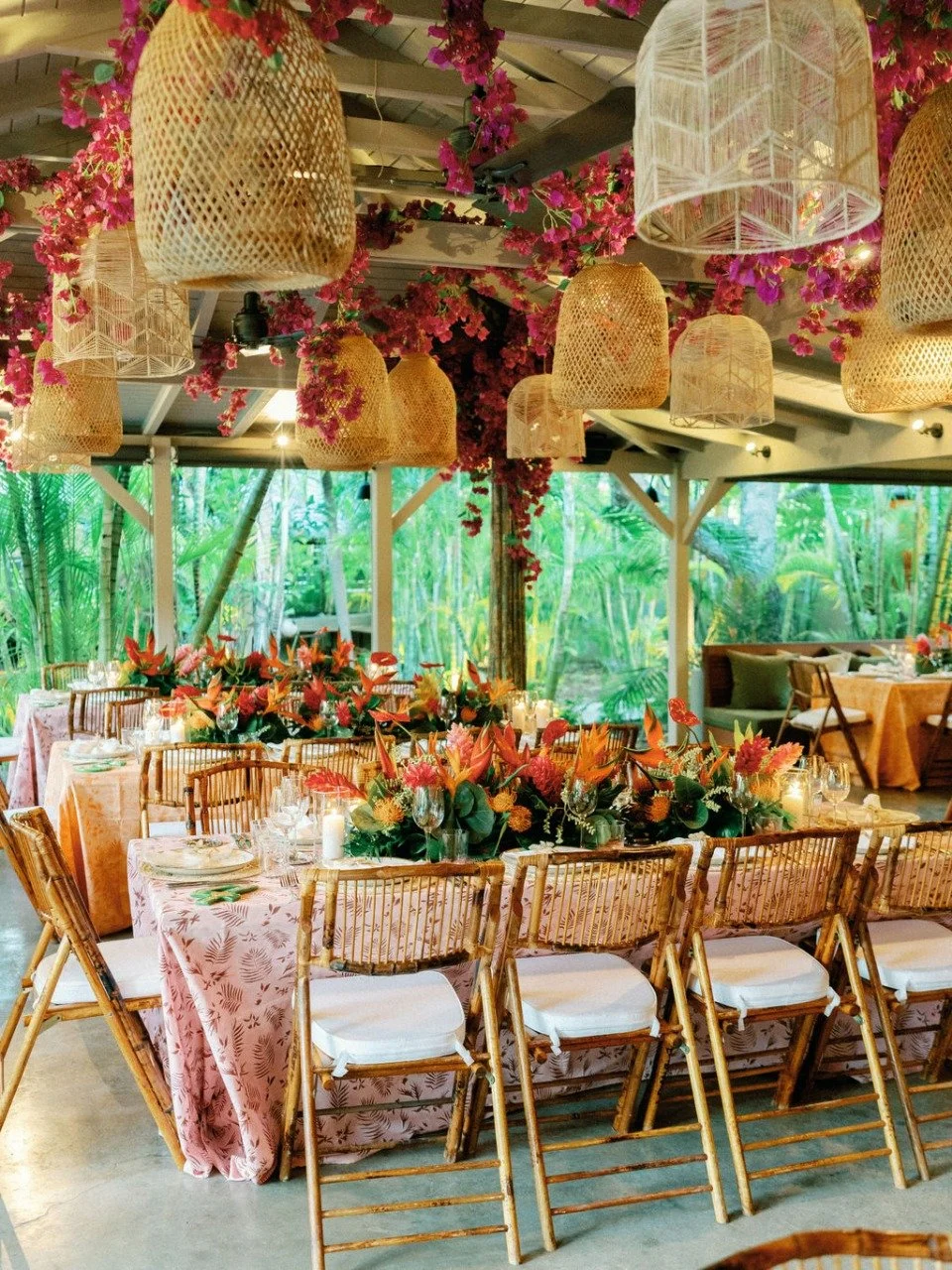 Tropical open-air restaurant setup with colorful floral arrangements and rattan lamps for a vibrant event in St Barth.