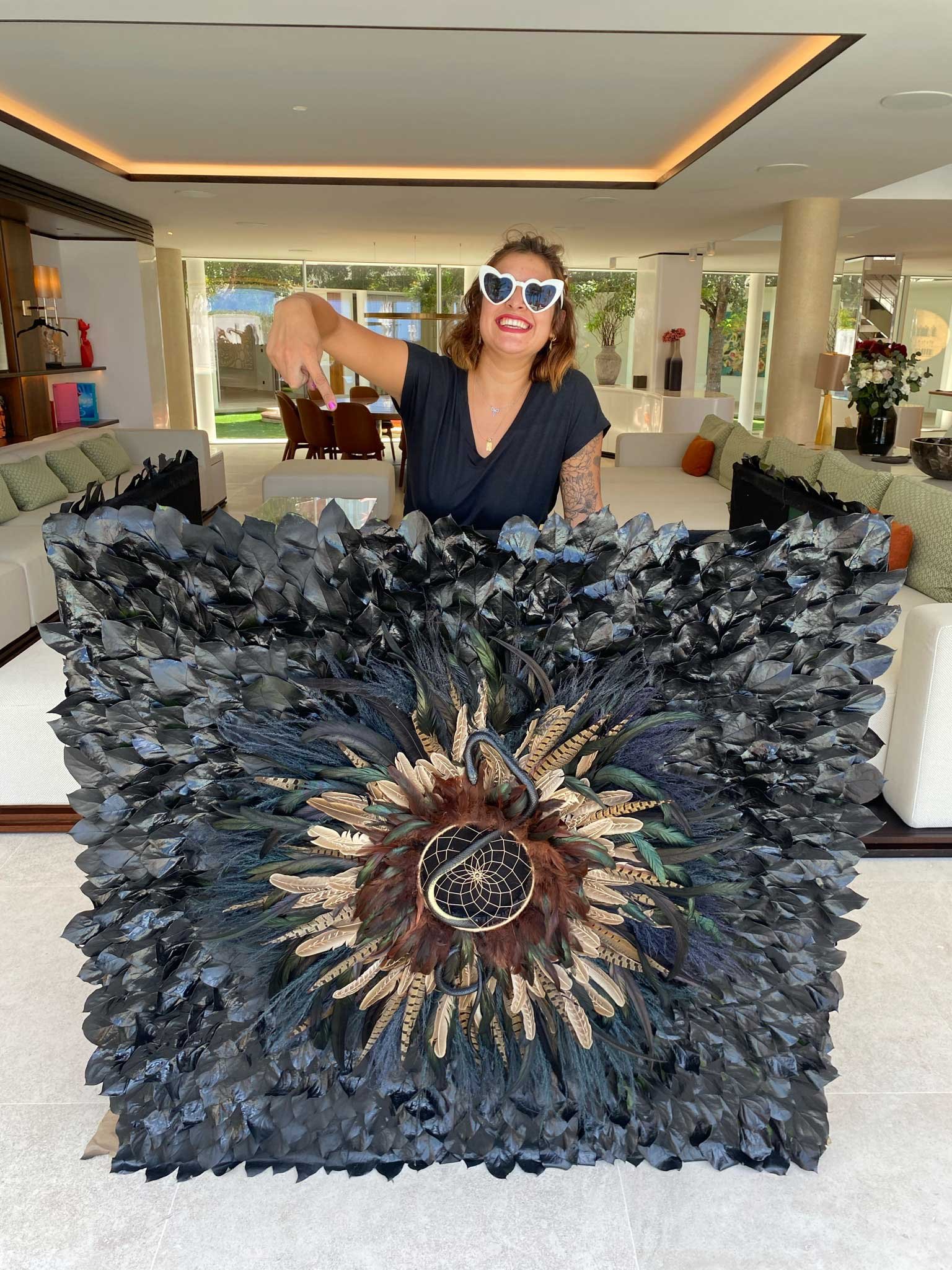 Event designer posing with a black and gold floral arrangement centerpiece during a luxury celebration in St Barth.