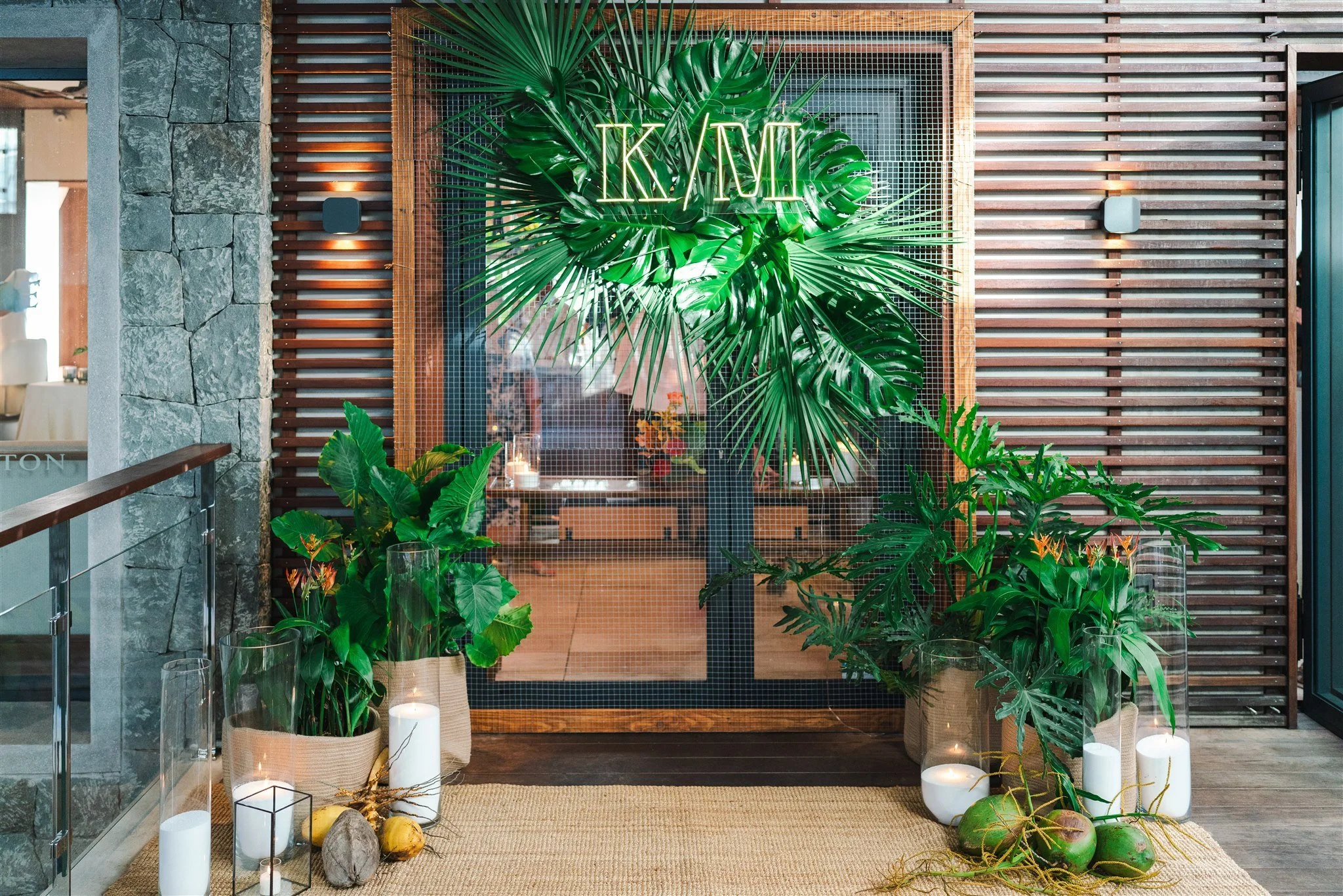 Tropical wedding entrance decorated with lush greenery and wooden details for a natural celebration in St Barth.