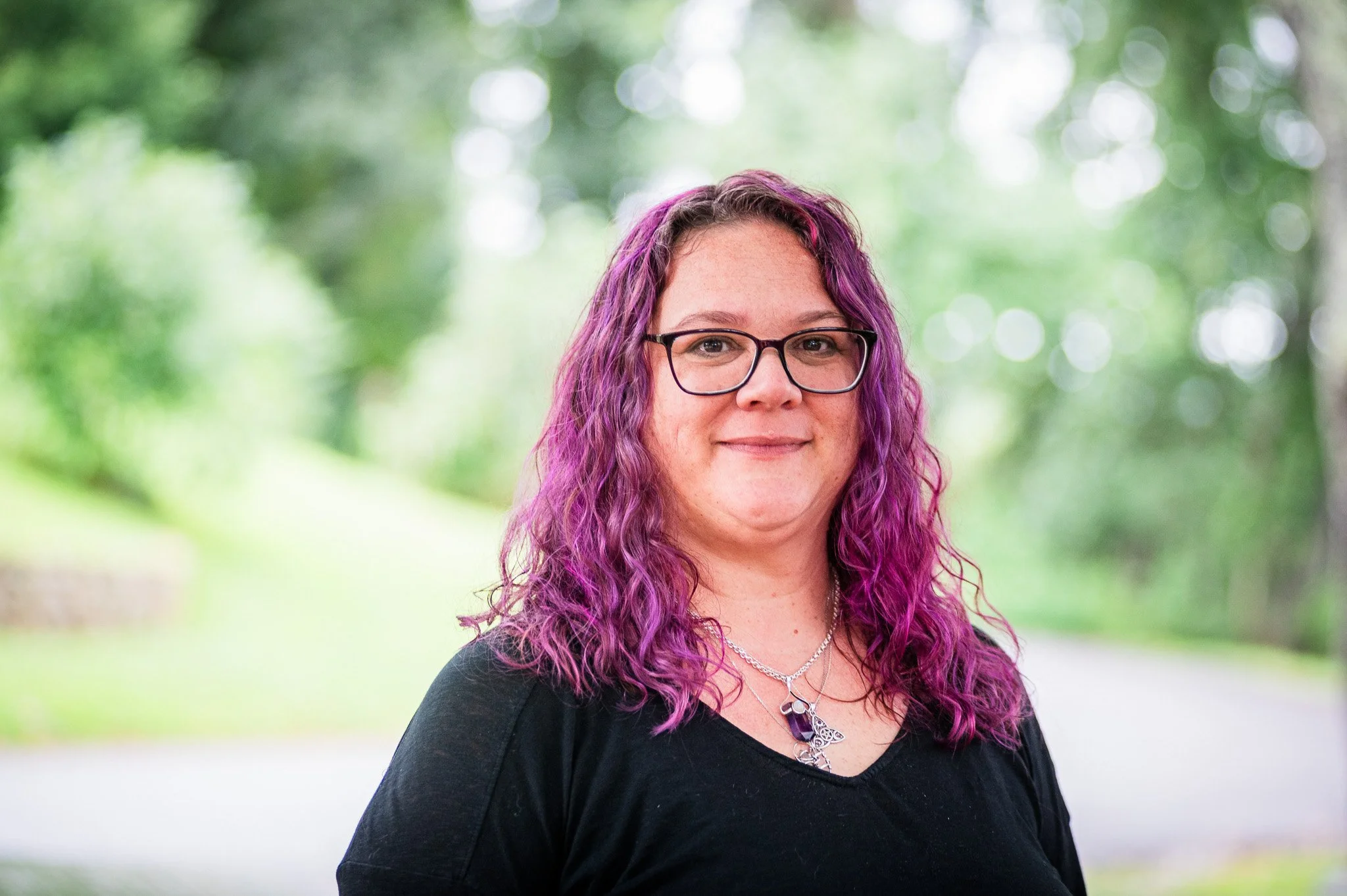 woman with purple hair confidently looking at the camera