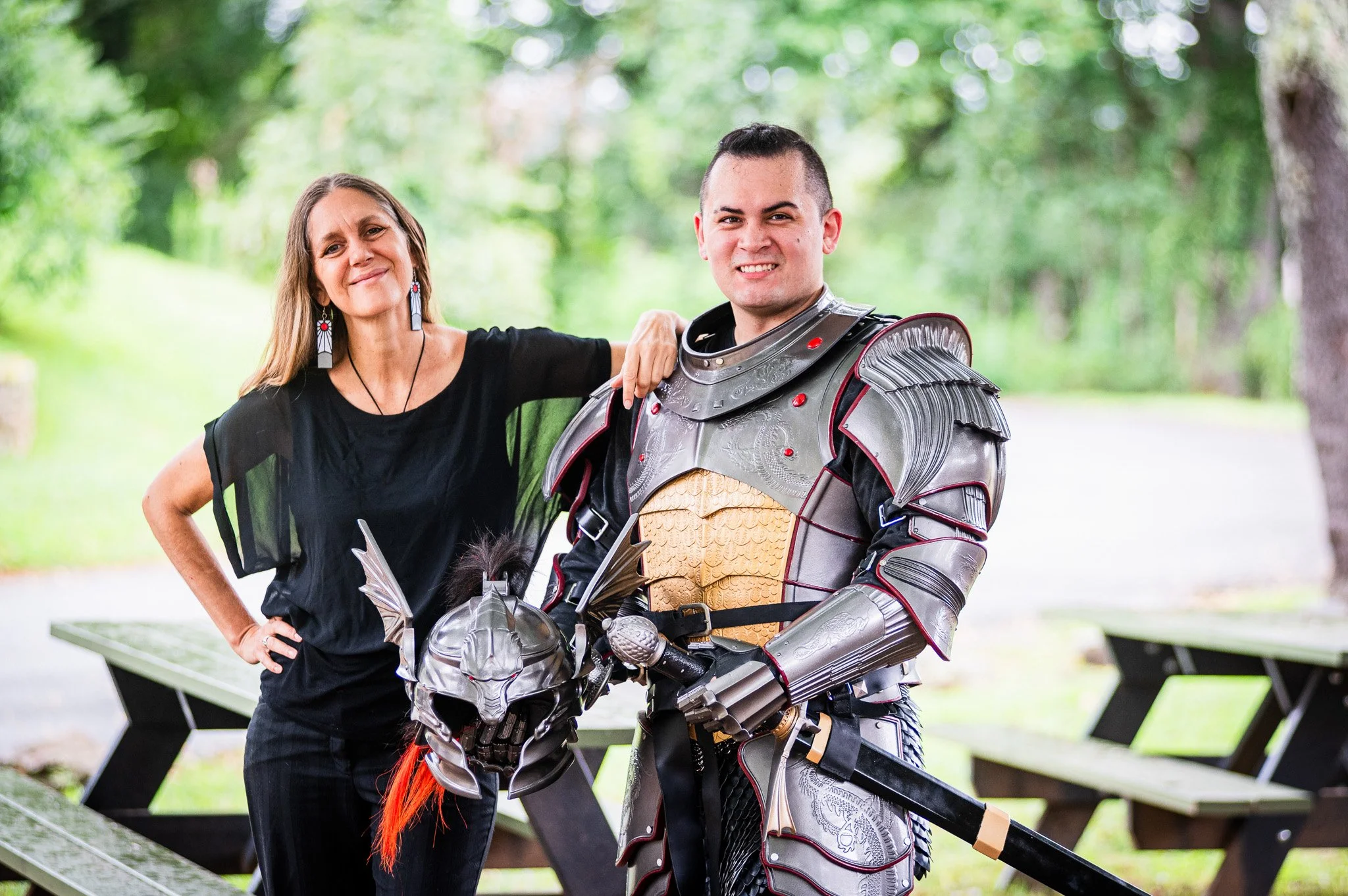 A woman and a man in medieval armor posing outdoors.