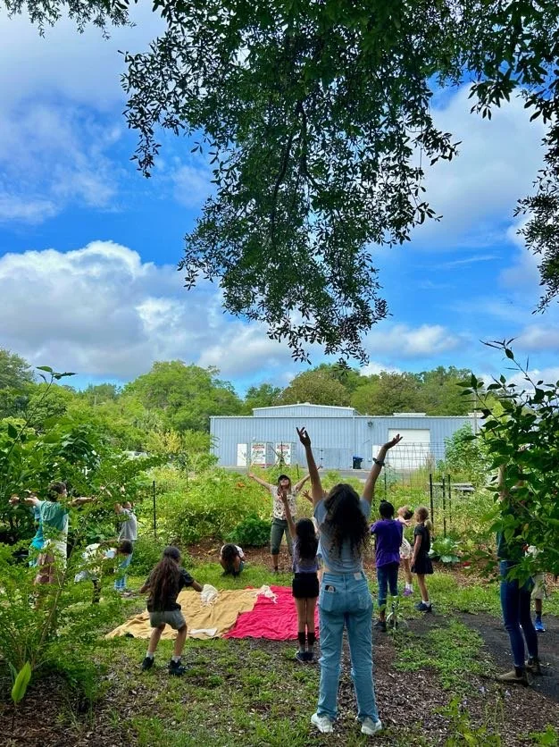 group of young people stand in a garden playing together.jpg