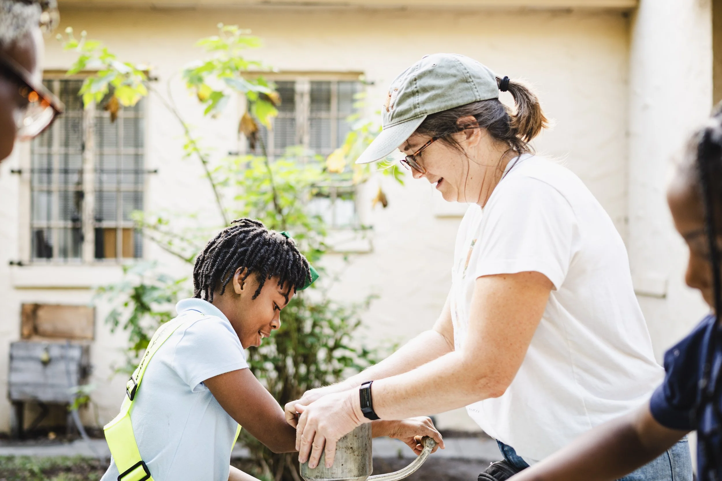 adult and child holding gardening tools