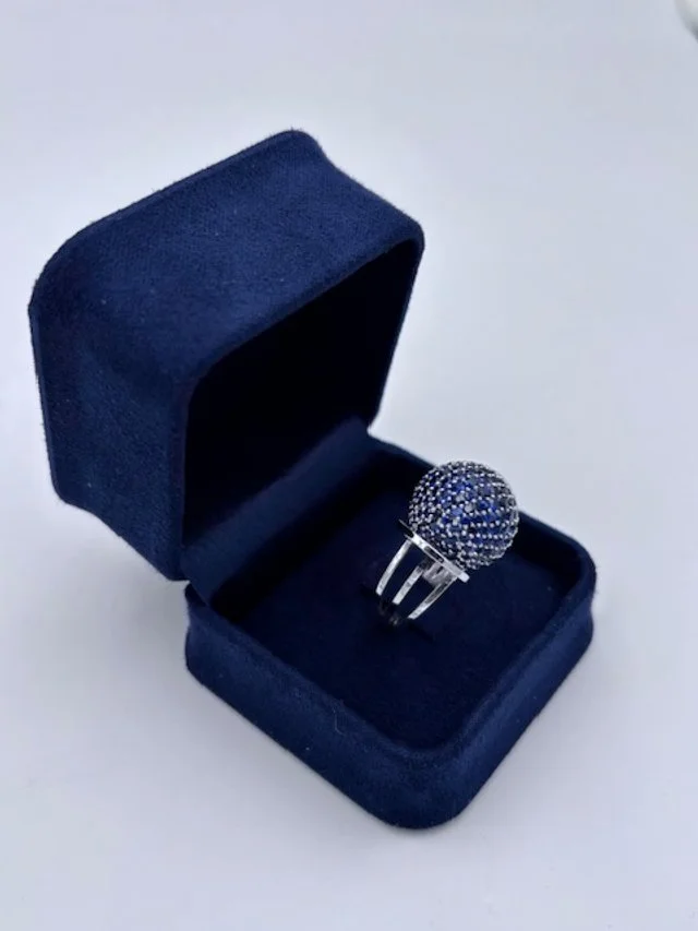 Anello con pietre blu in un astuccio di velluto blu