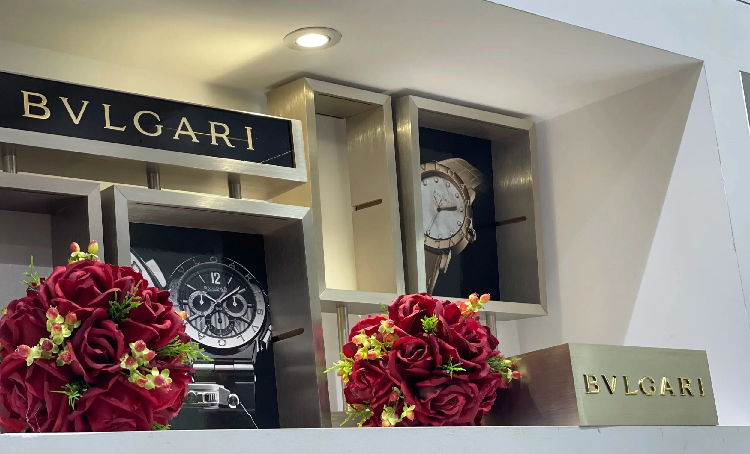 Vetrina di una boutique Bulgari con orologi e rose rosse