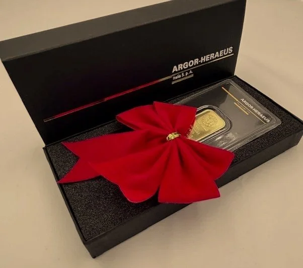 Lingotto d'oro in confezione nera con fiocco rosso