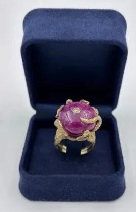 Anello con decorazione rosa in un cofanetto blu.