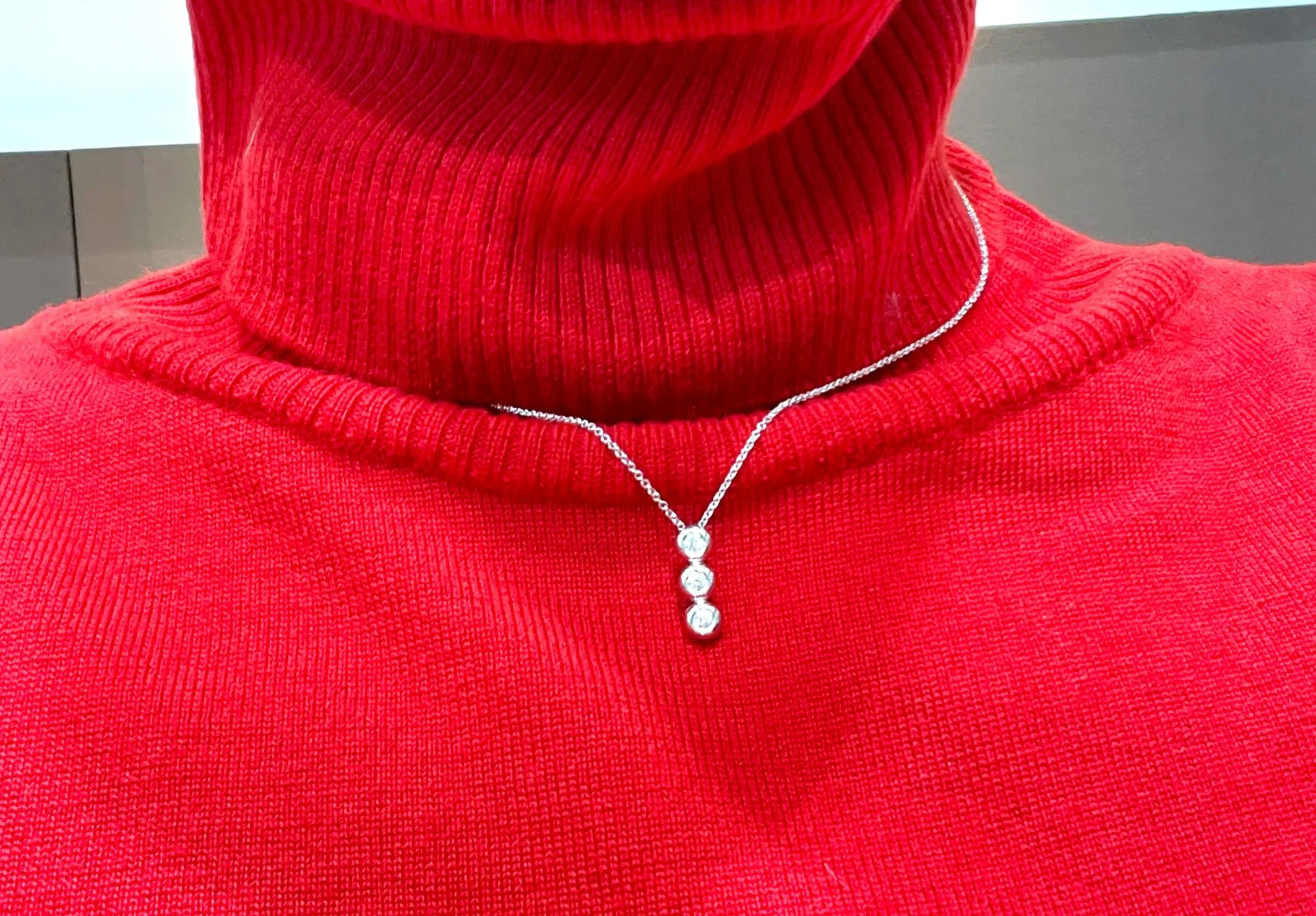 Collana Trilogy con brillanti su maglione rosso