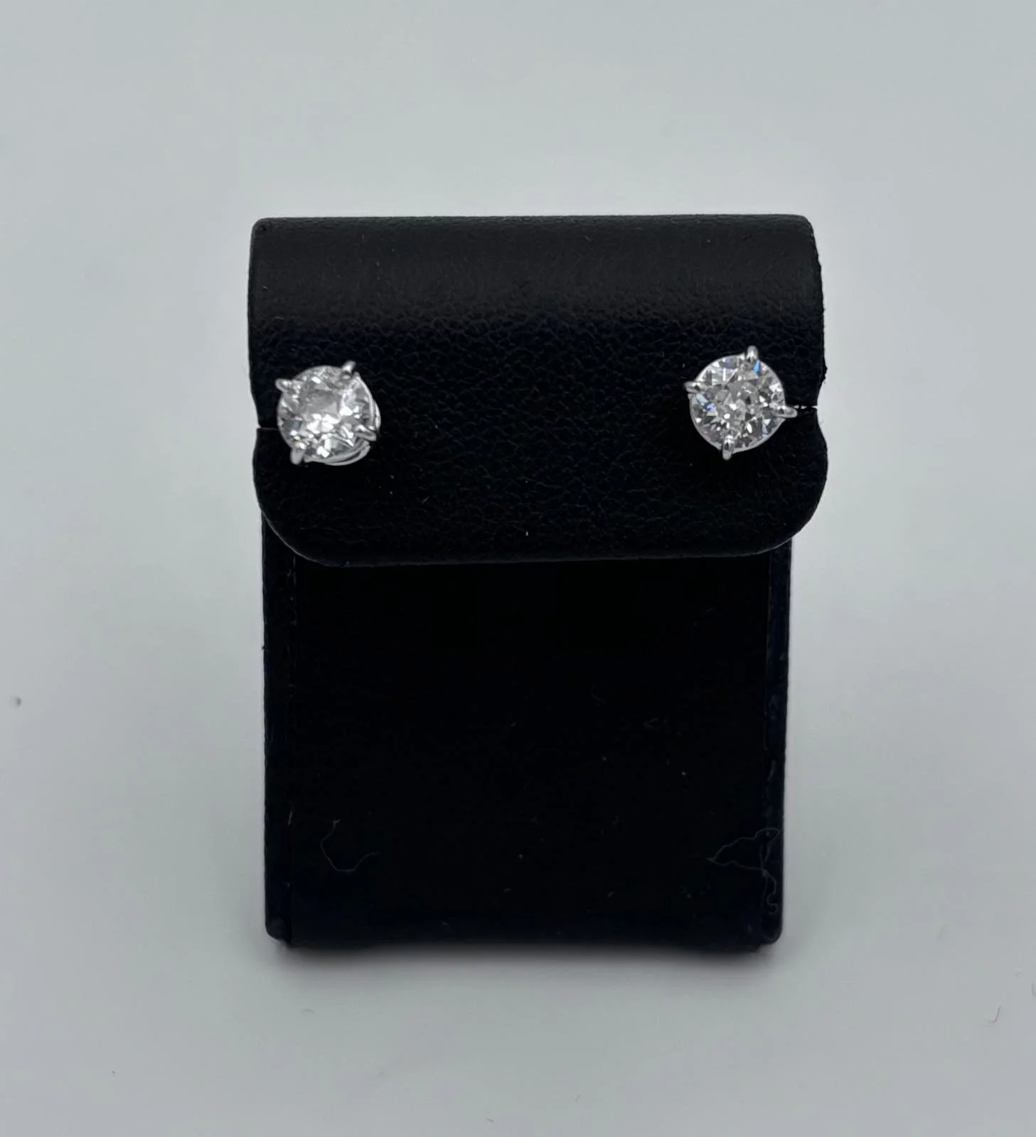 Orecchini punto luce in oro bianco 18K con diamanti su espositore nero