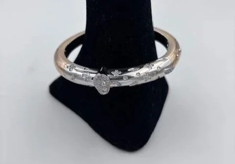 Bracciale rigido in oro cesellato su espositore nero