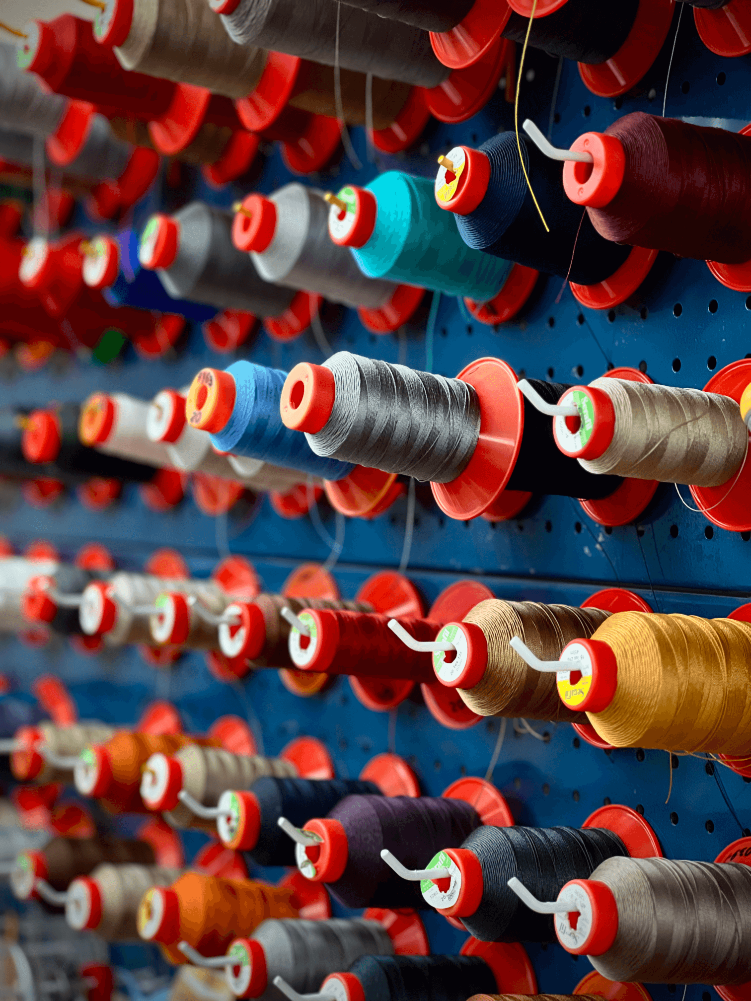 Стенд із широким асортиментом кольорових ниток для пошиття автомобільних салонів.