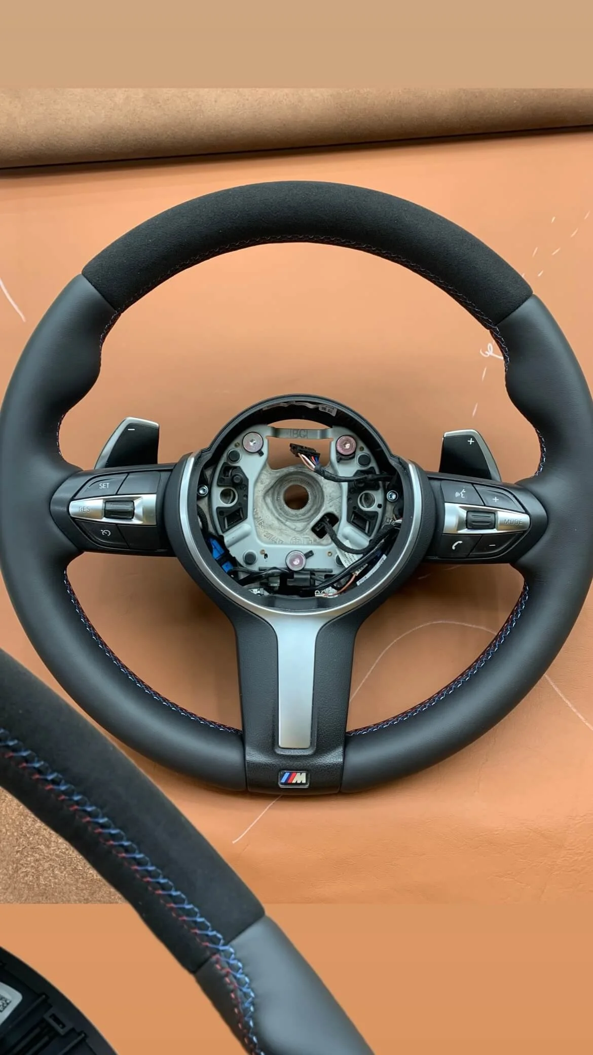 Кермо BMW M-серії: комбінація гладкої шкіри та алькантари з фірмовим триколірним M-швом