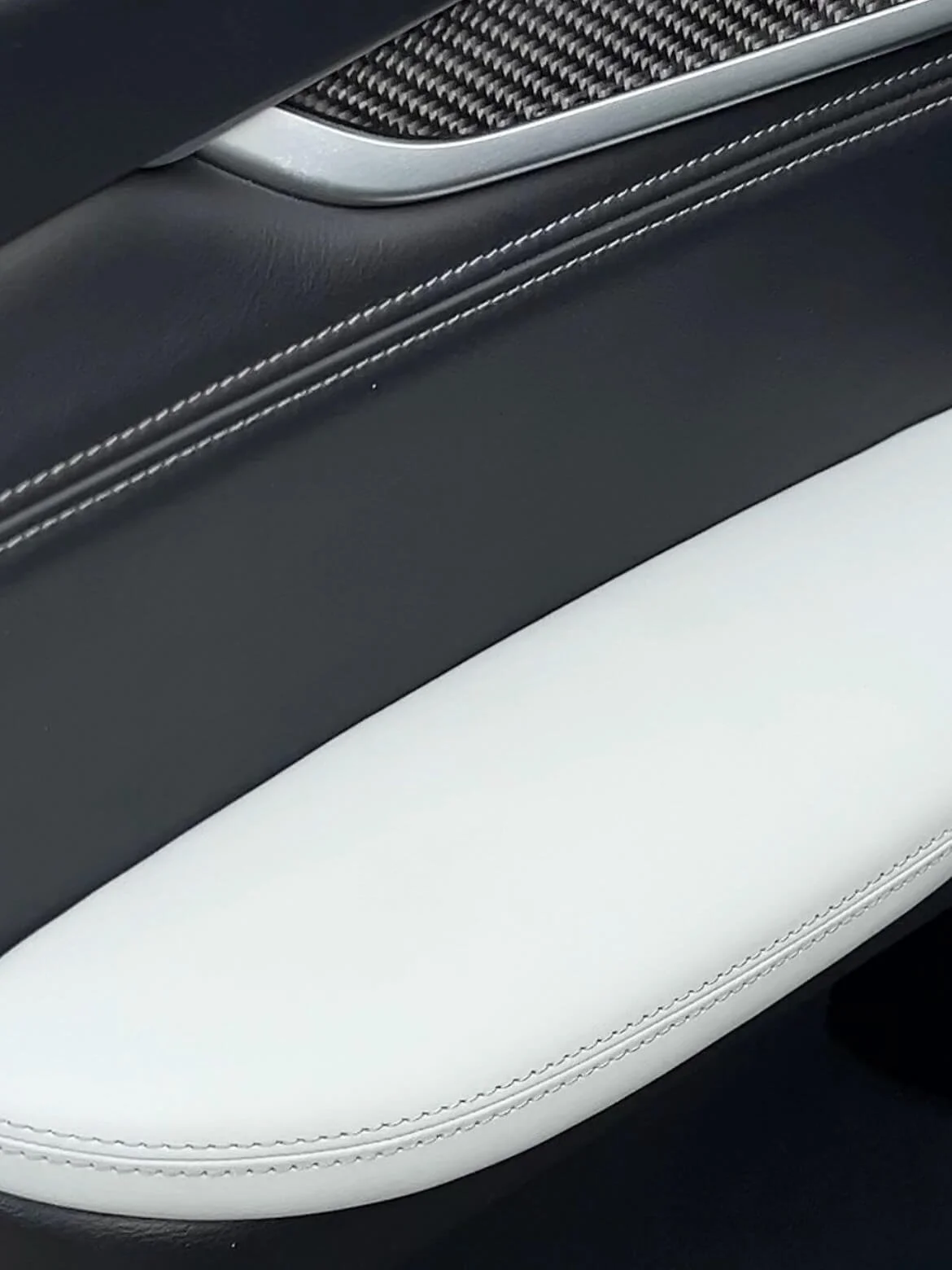 Елемент дверної карти: поєднання карбону, чорної шкіри та білого шкіряного підлокітника з прострочкою