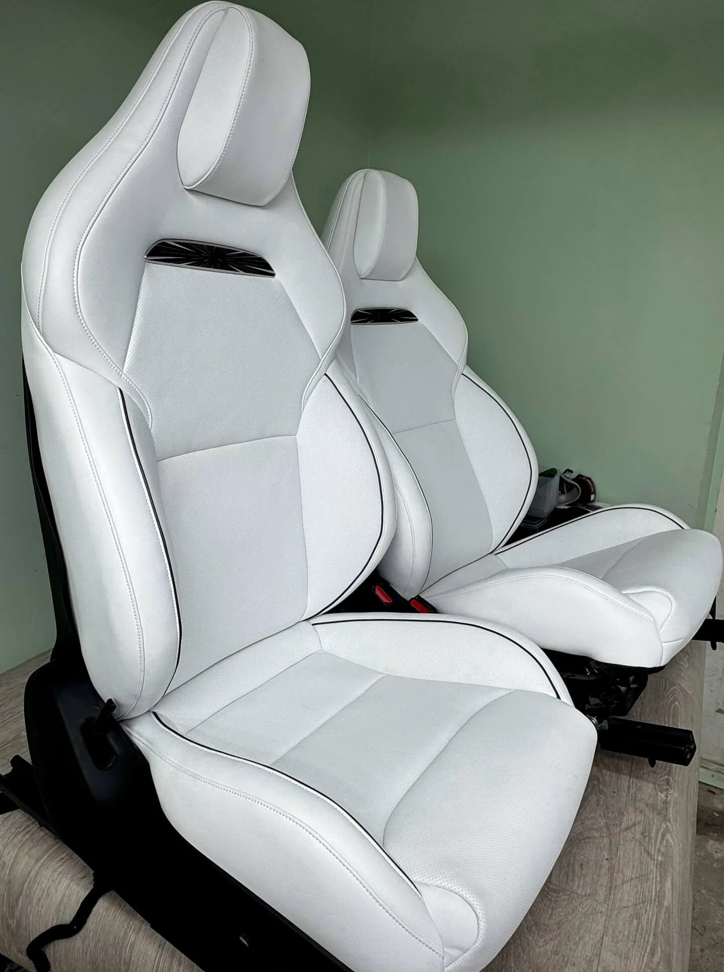 Два спортивних сидіння, перешиті в білу перфоровану шкіру з чорним кантом та логотипом