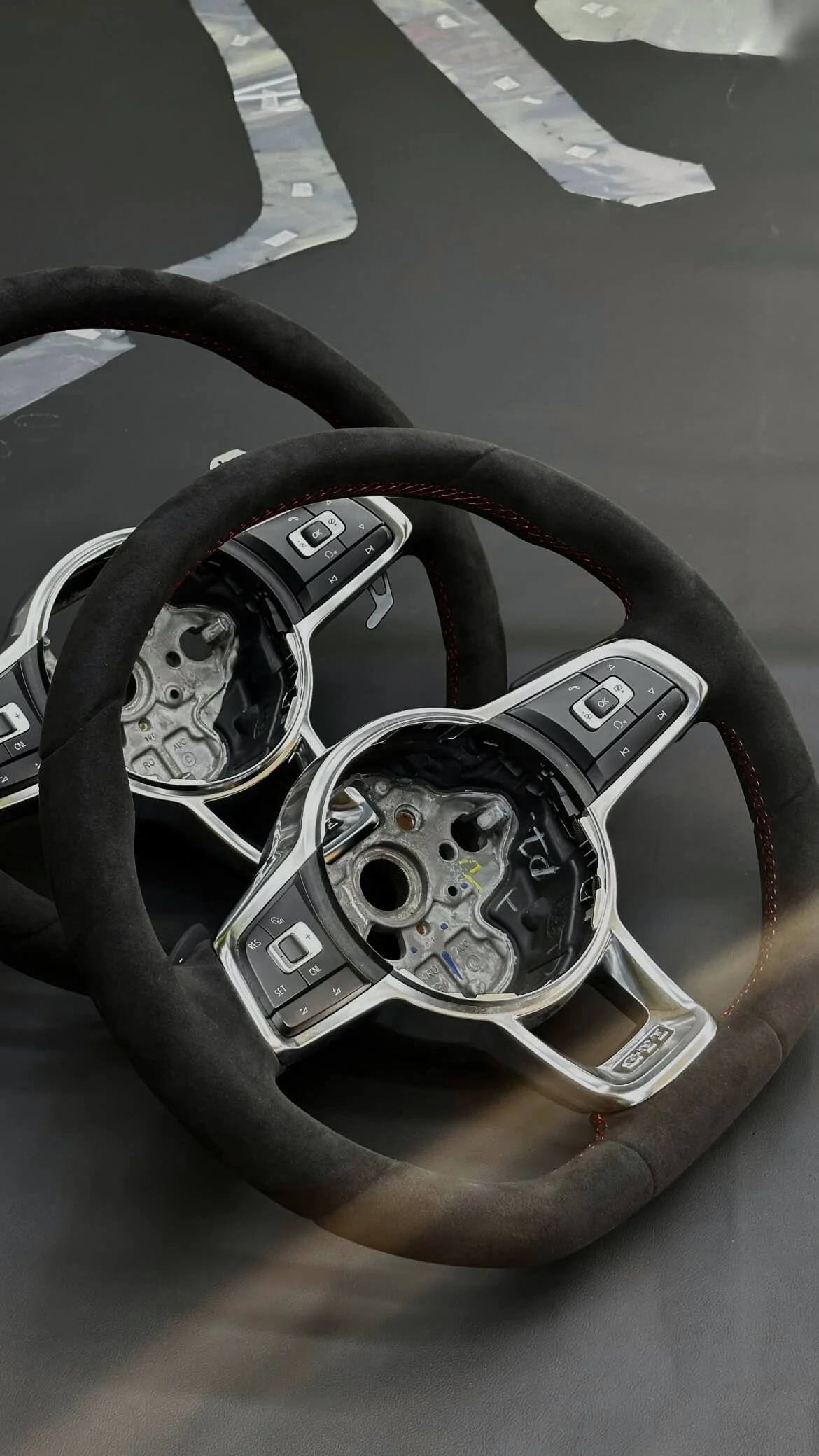 Процес роботи: два спортивних керма перетягнуті в алькантару з червоним швом