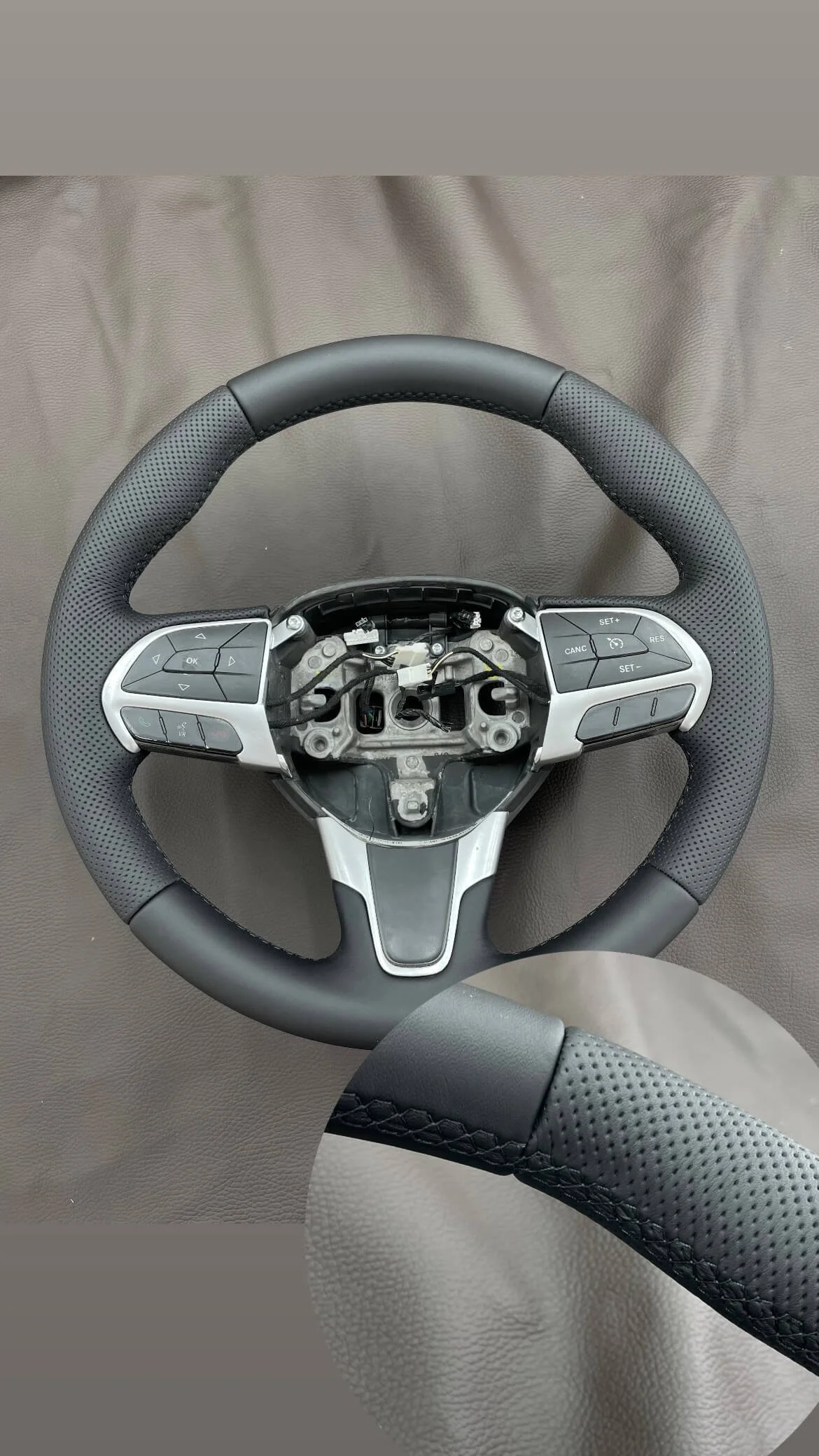 Кермо перетягнуте в чорну шкіру з перфорацією, макрозйомка якості декоративного шва