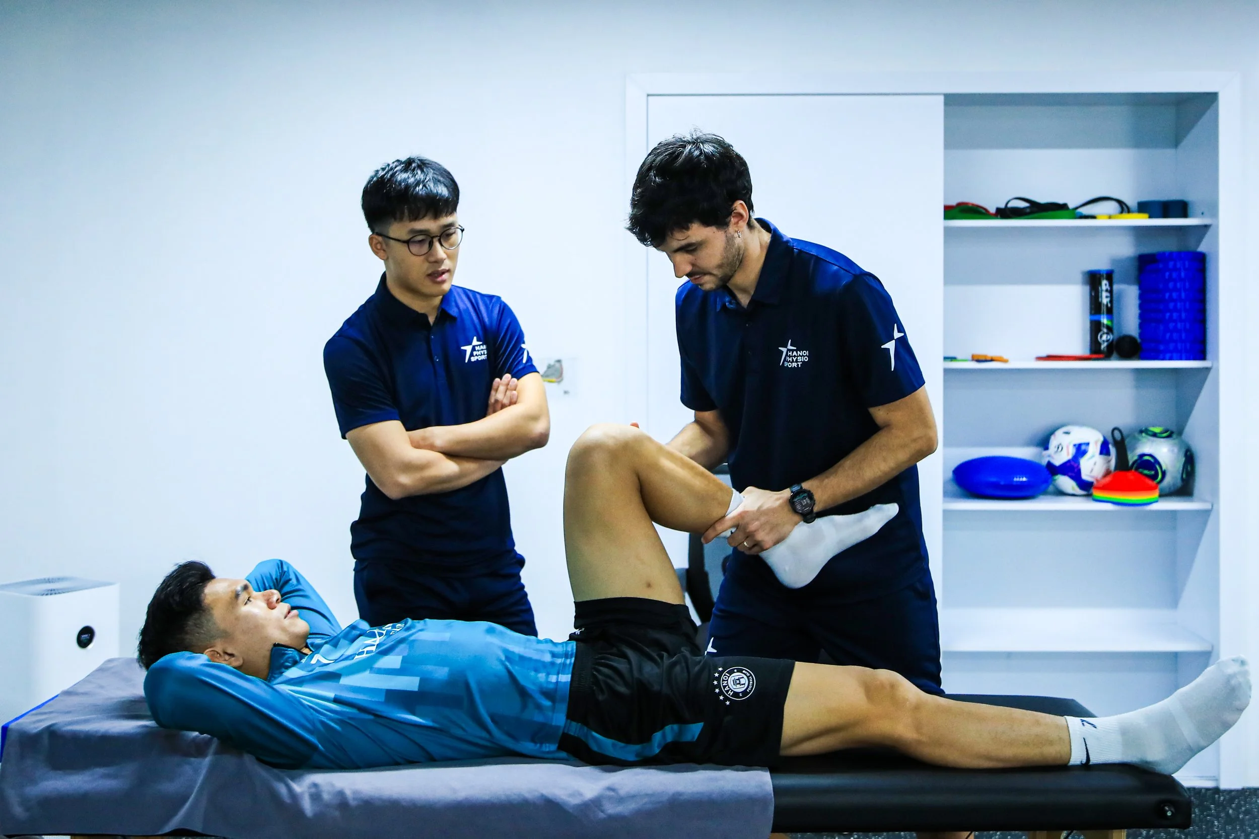 Sports physiotherapist guiding an athlete during ACL rehabilitation exercises at Vietnam Physio Sport in Vietnam.