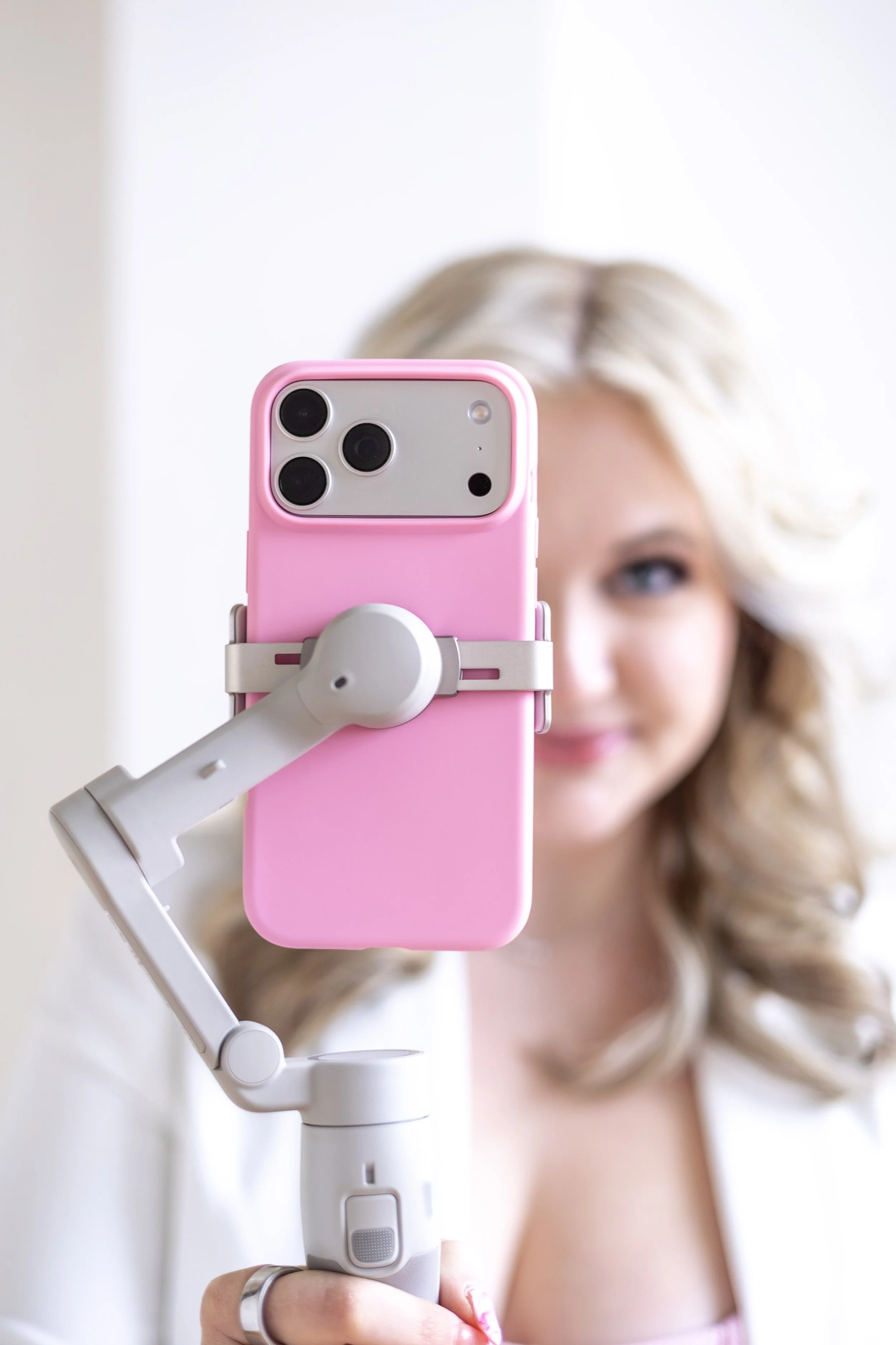 Smartphone displaying a photo gallery of outdoor scenes and landmarks, resting on a white surface next to a laptop keyboard.